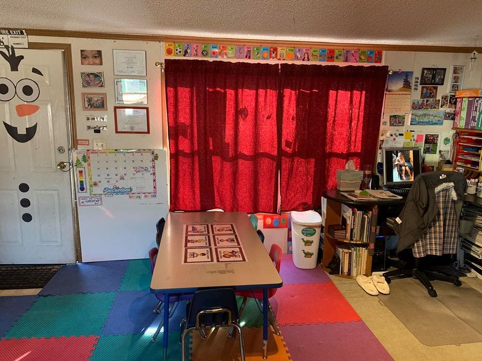 Classroom with a small table, red curtains, and a computer desk