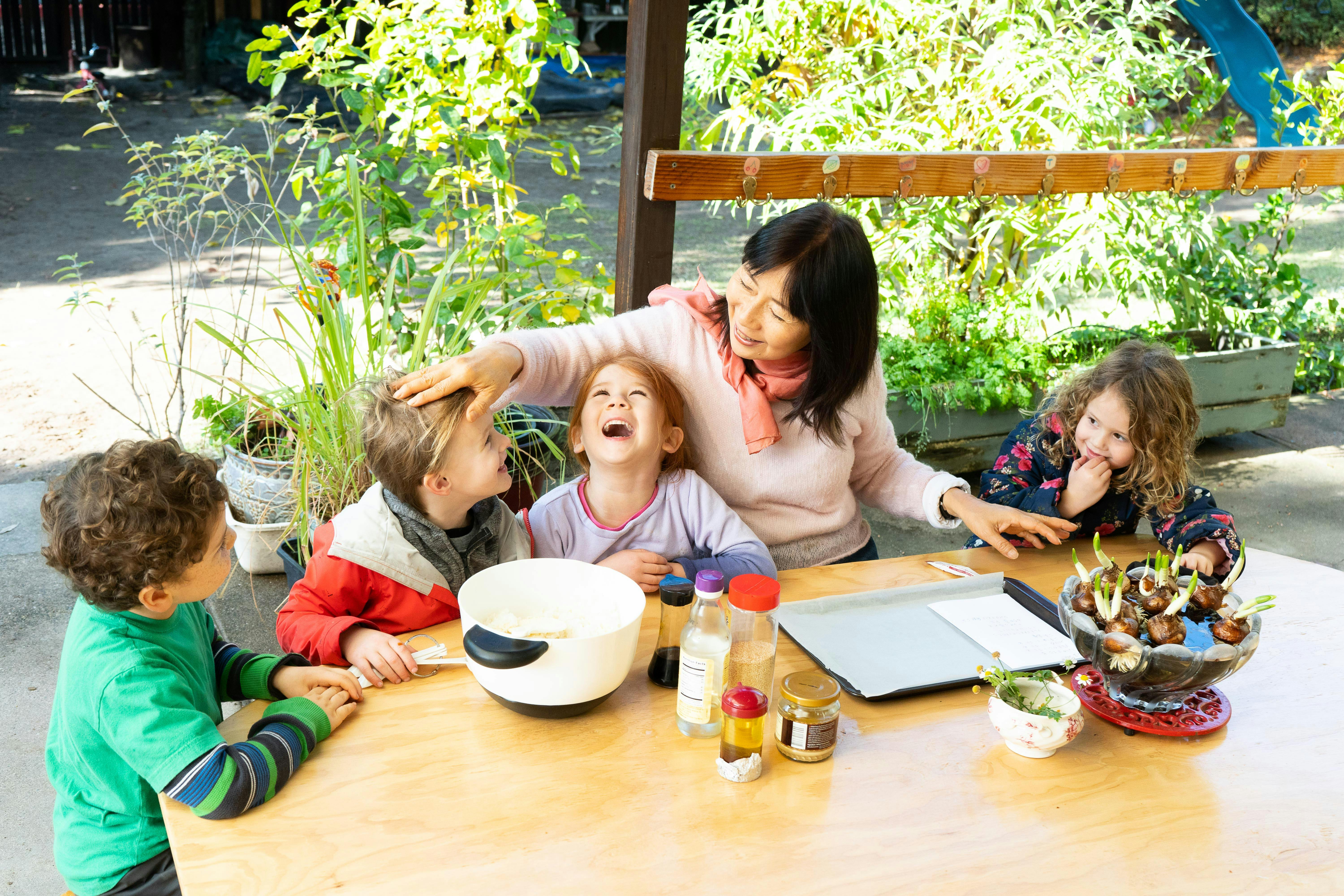 Adult and three children at a table with bowls and bottles