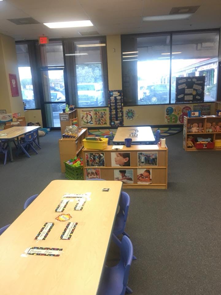 Classroom with tables, chairs, and shelves with learning materials