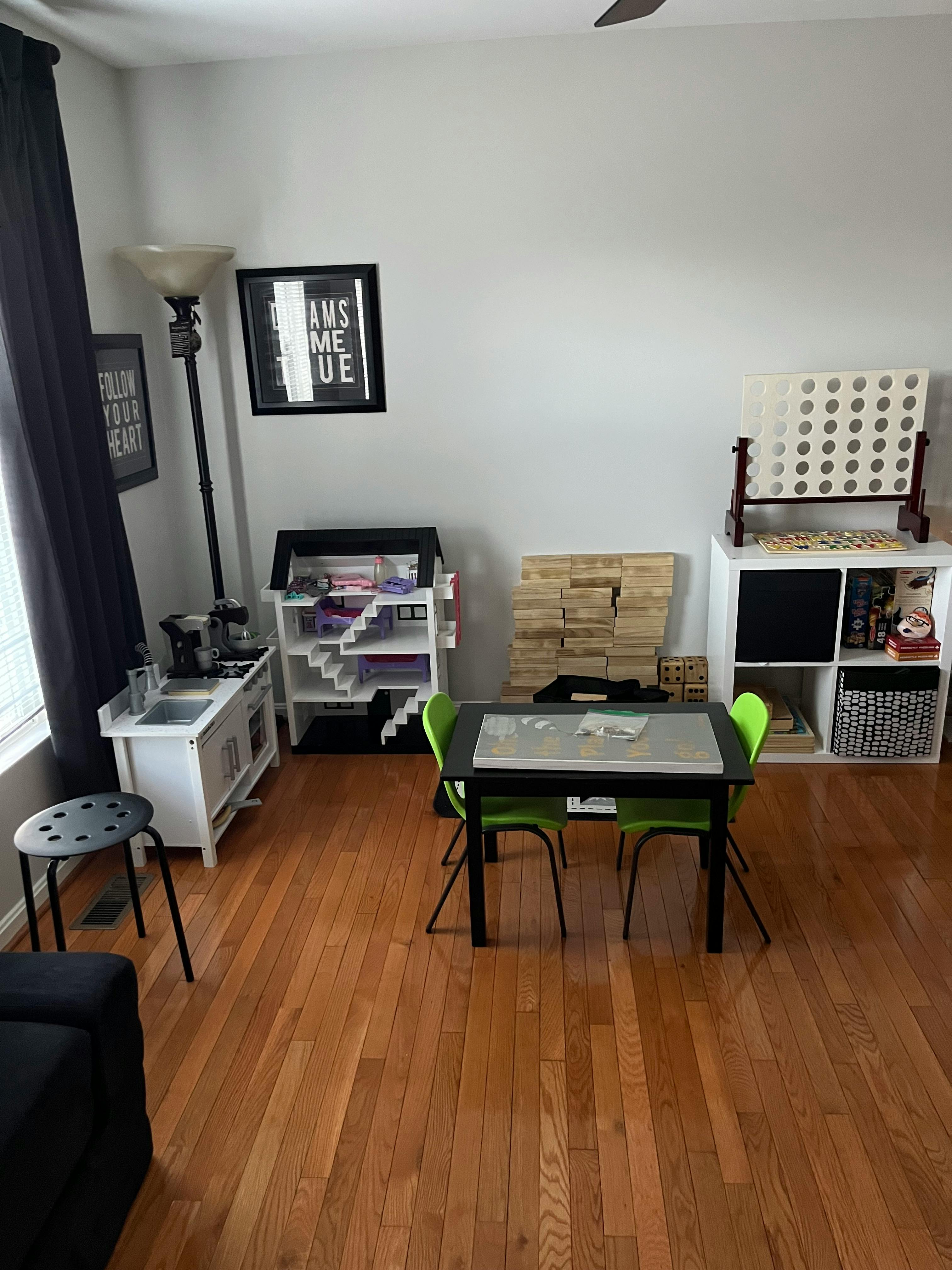 Playroom with a small table and chairs, toy kitchen, and storage shelves