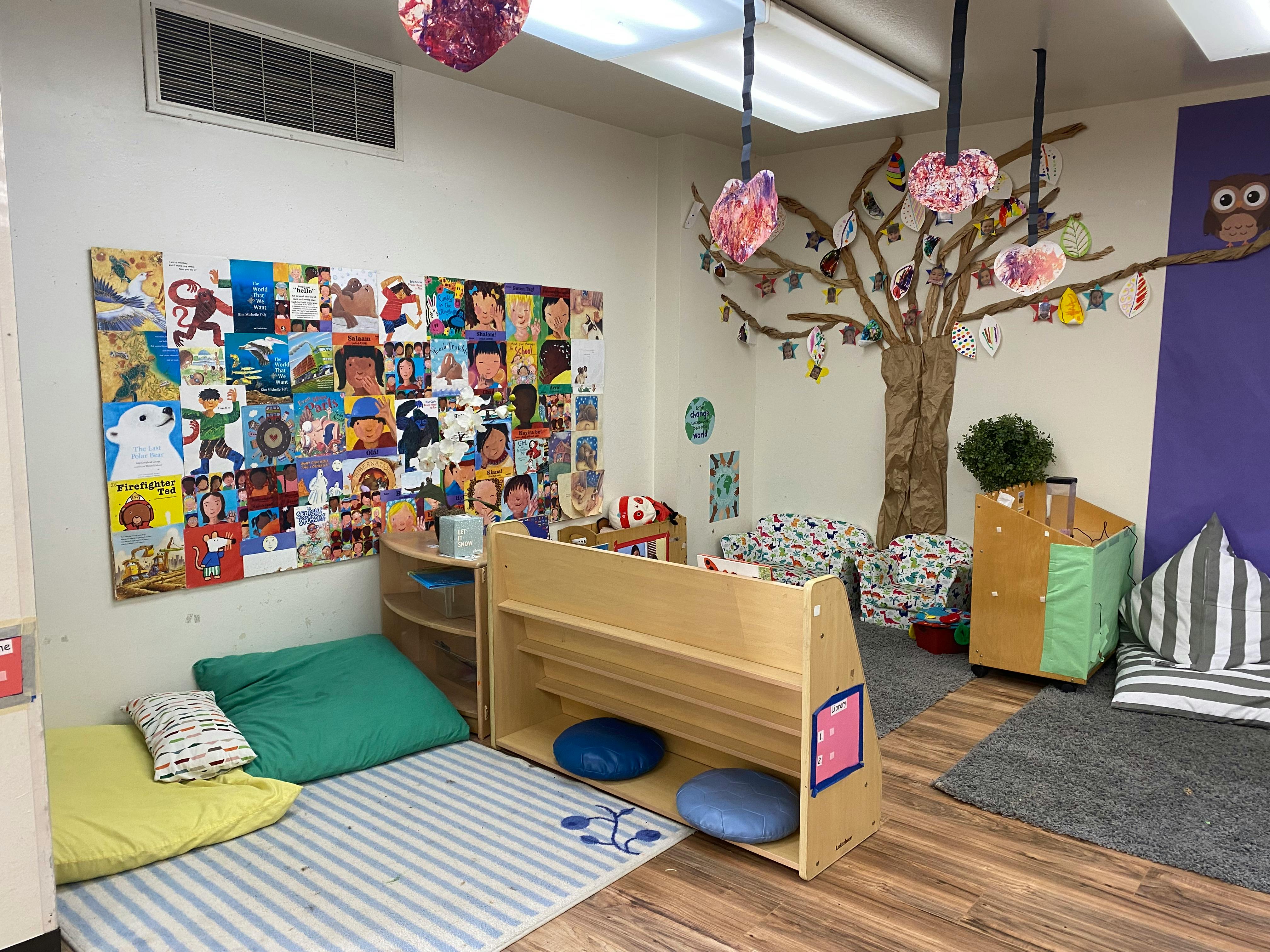 Children's room with a wall collage, floor cushions, and a tree decoration