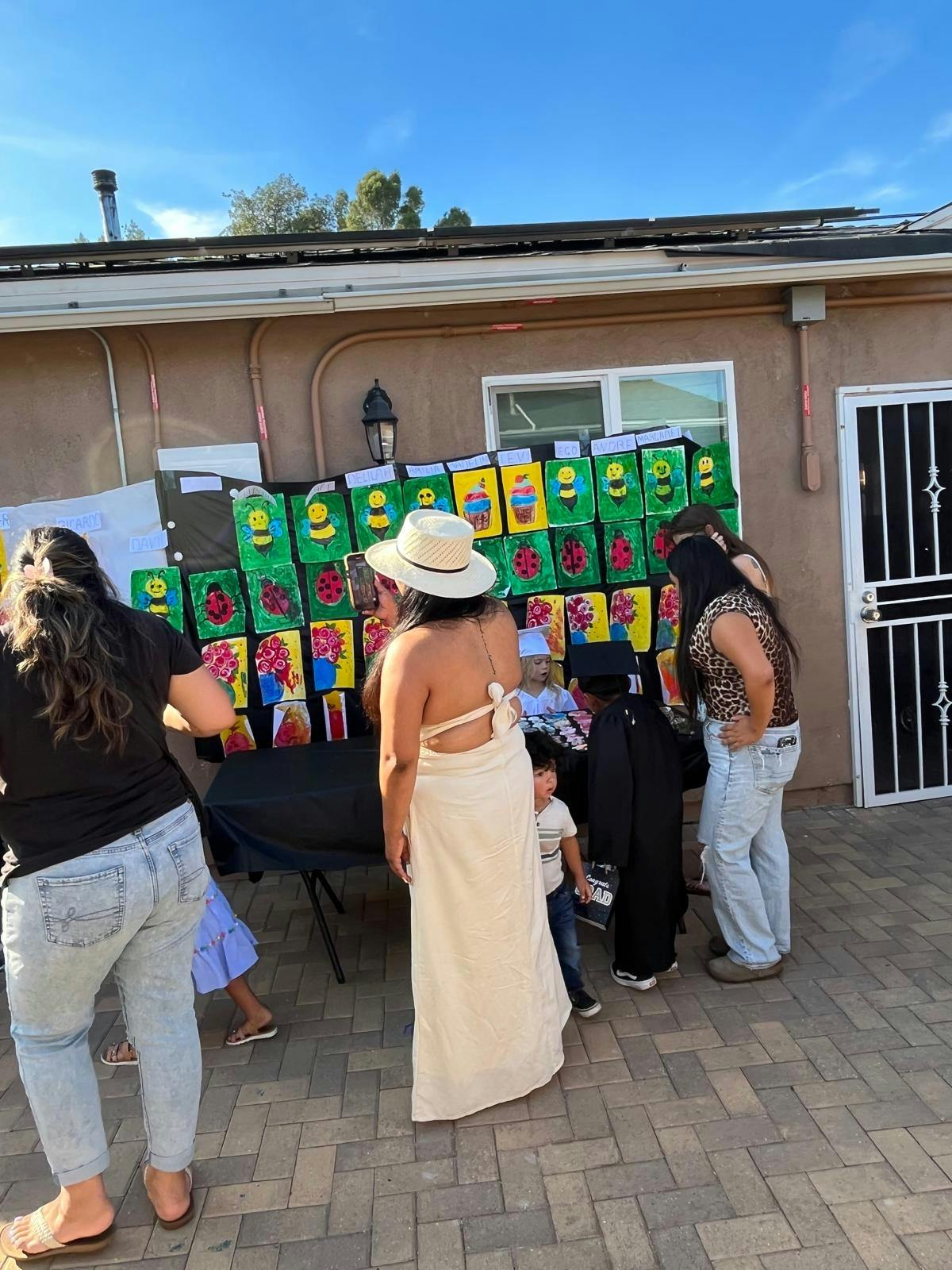 People gathered around a display of colorful artwork