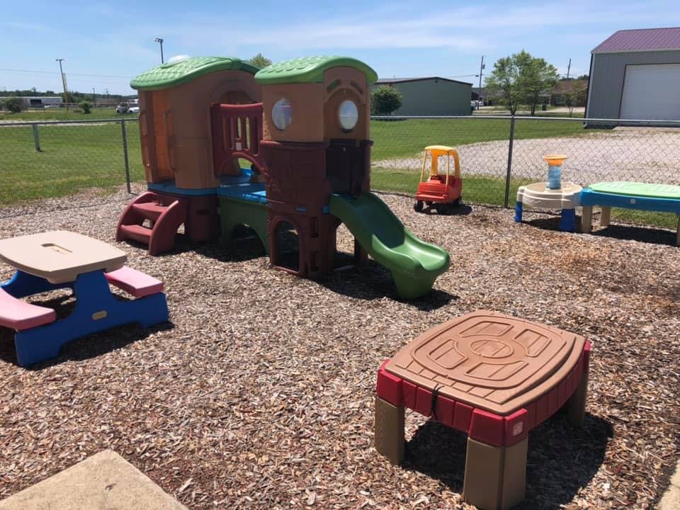 Playground with a play structure, slide, and small tables