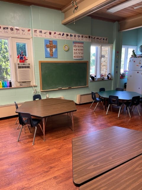 Classroom with tables, chairs, and a chalkboard