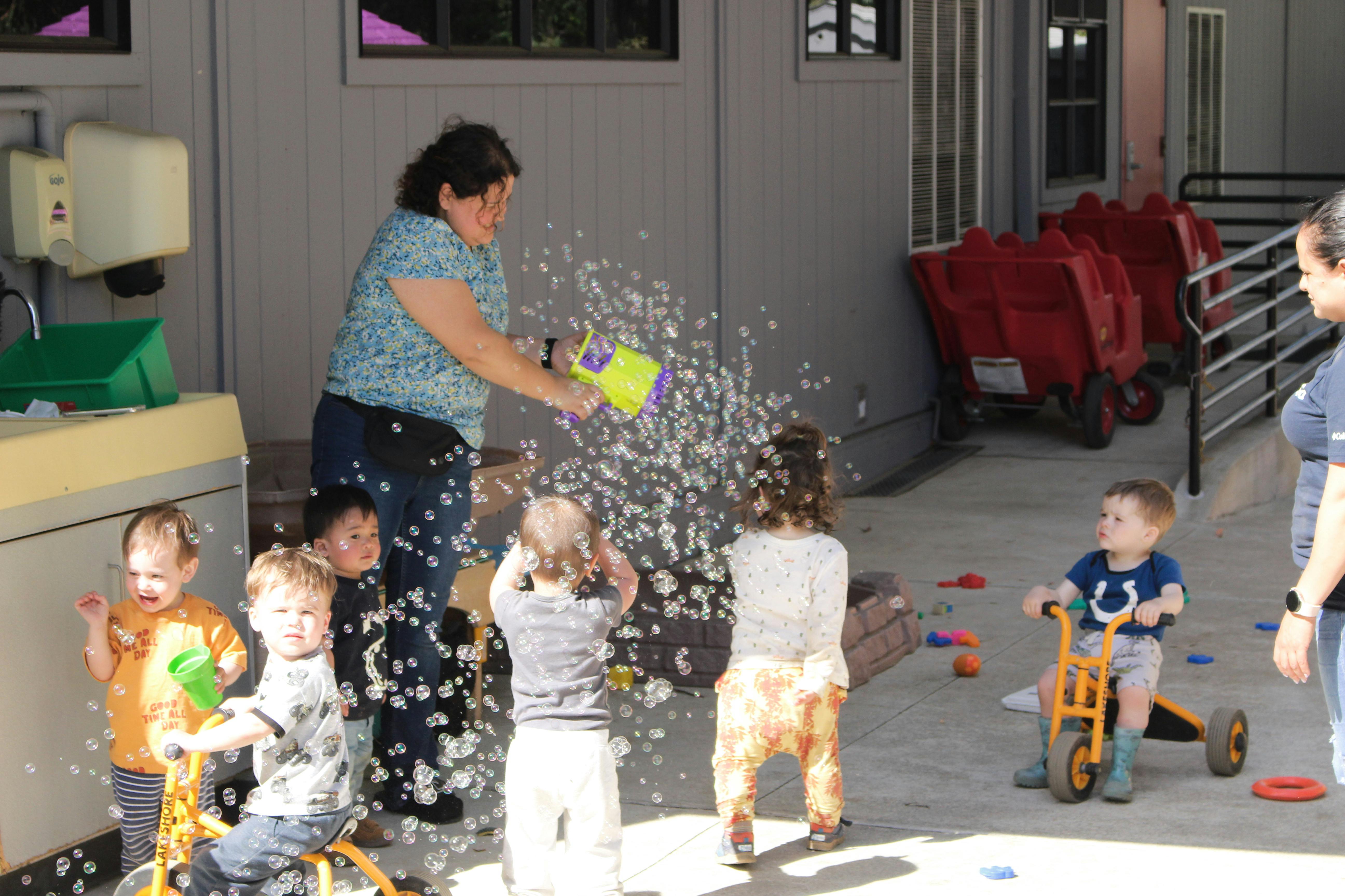 Person spraying foam on children playing outdoors