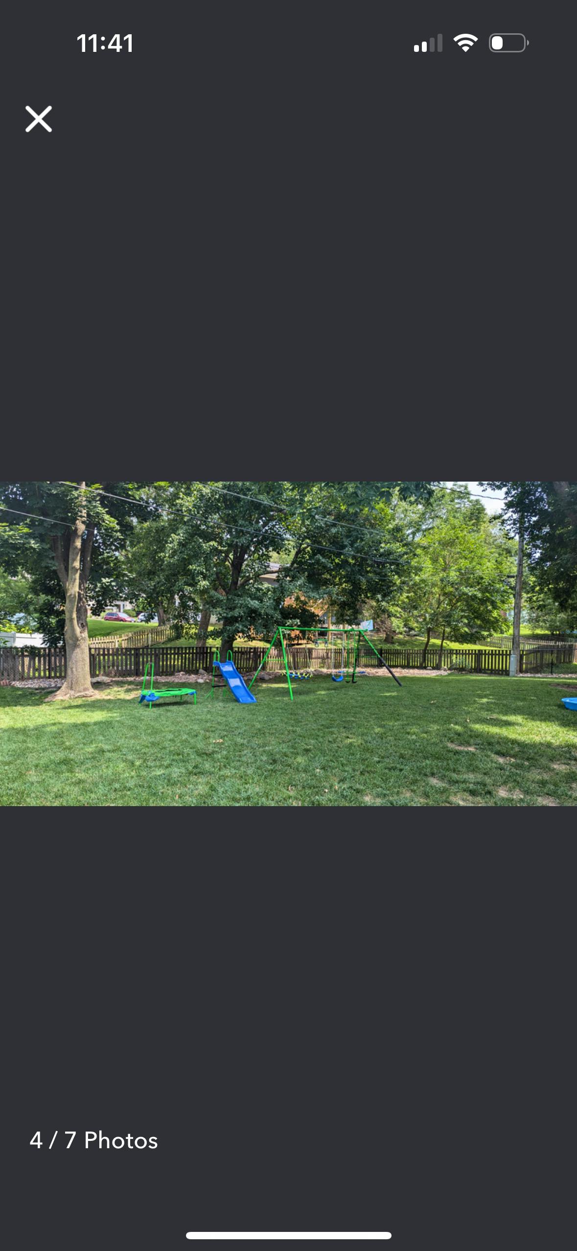 Backyard with a blue slide and green swing set