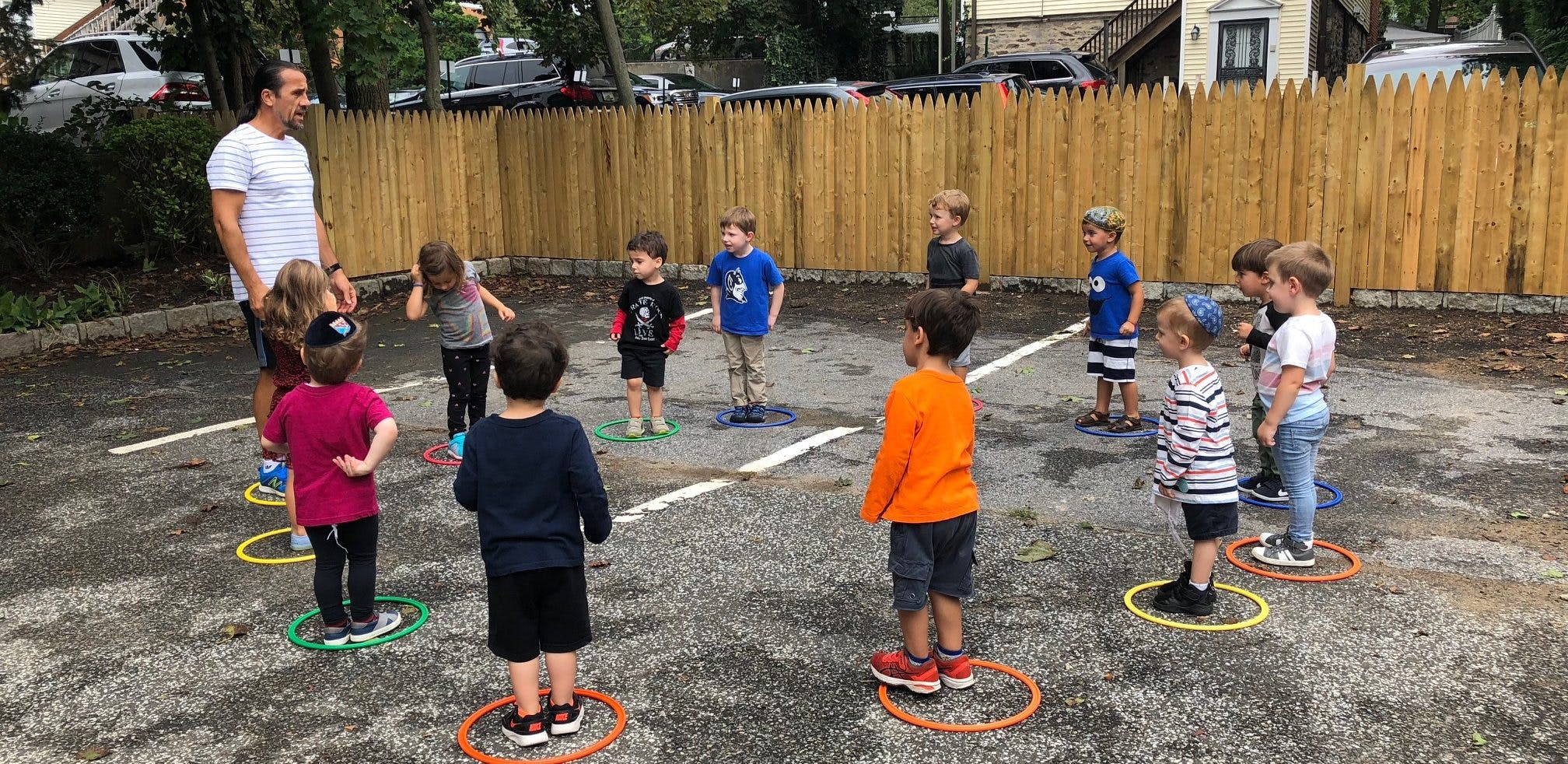 Adult and children standing in circles on pavement