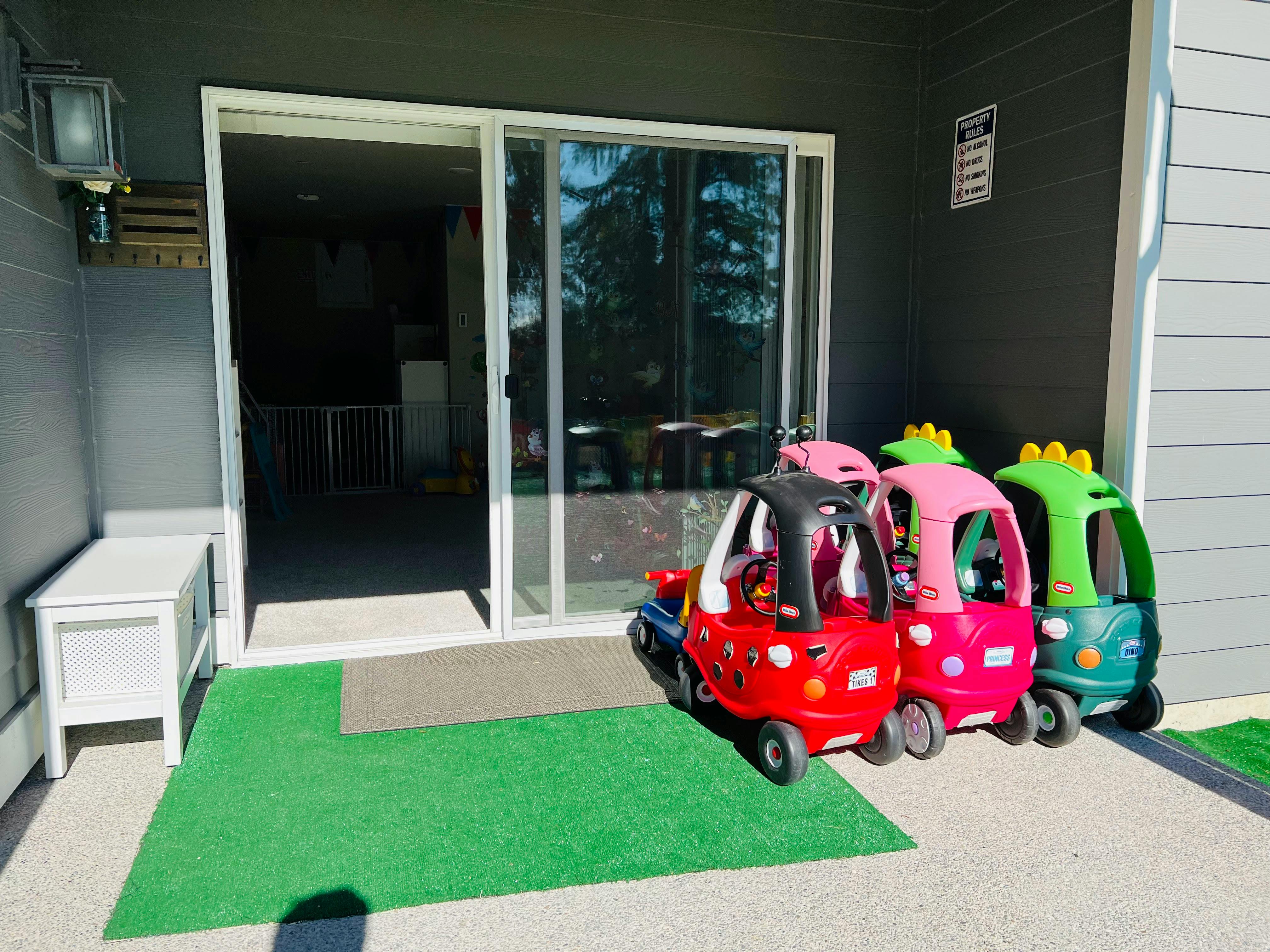 Three toy cars parked outside a sliding glass door