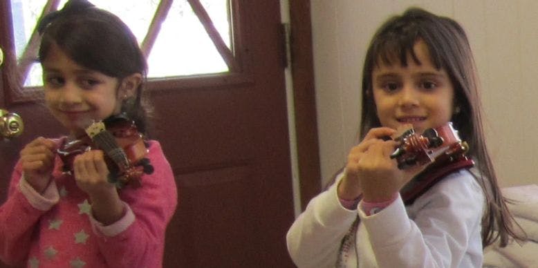 Two children holding small toy cars