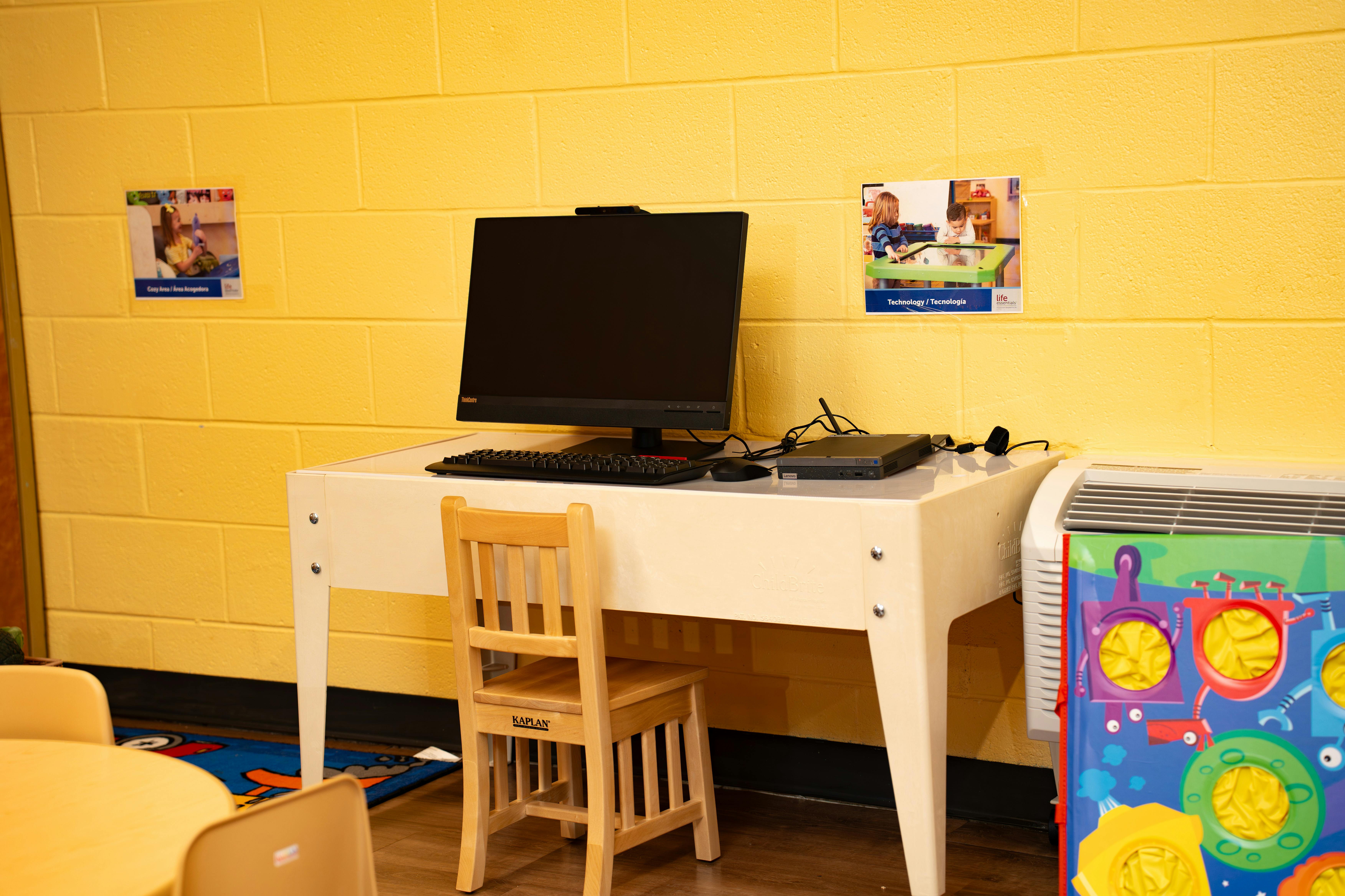 A computer station with a desktop monitor, keyboard, and mouse on a white table