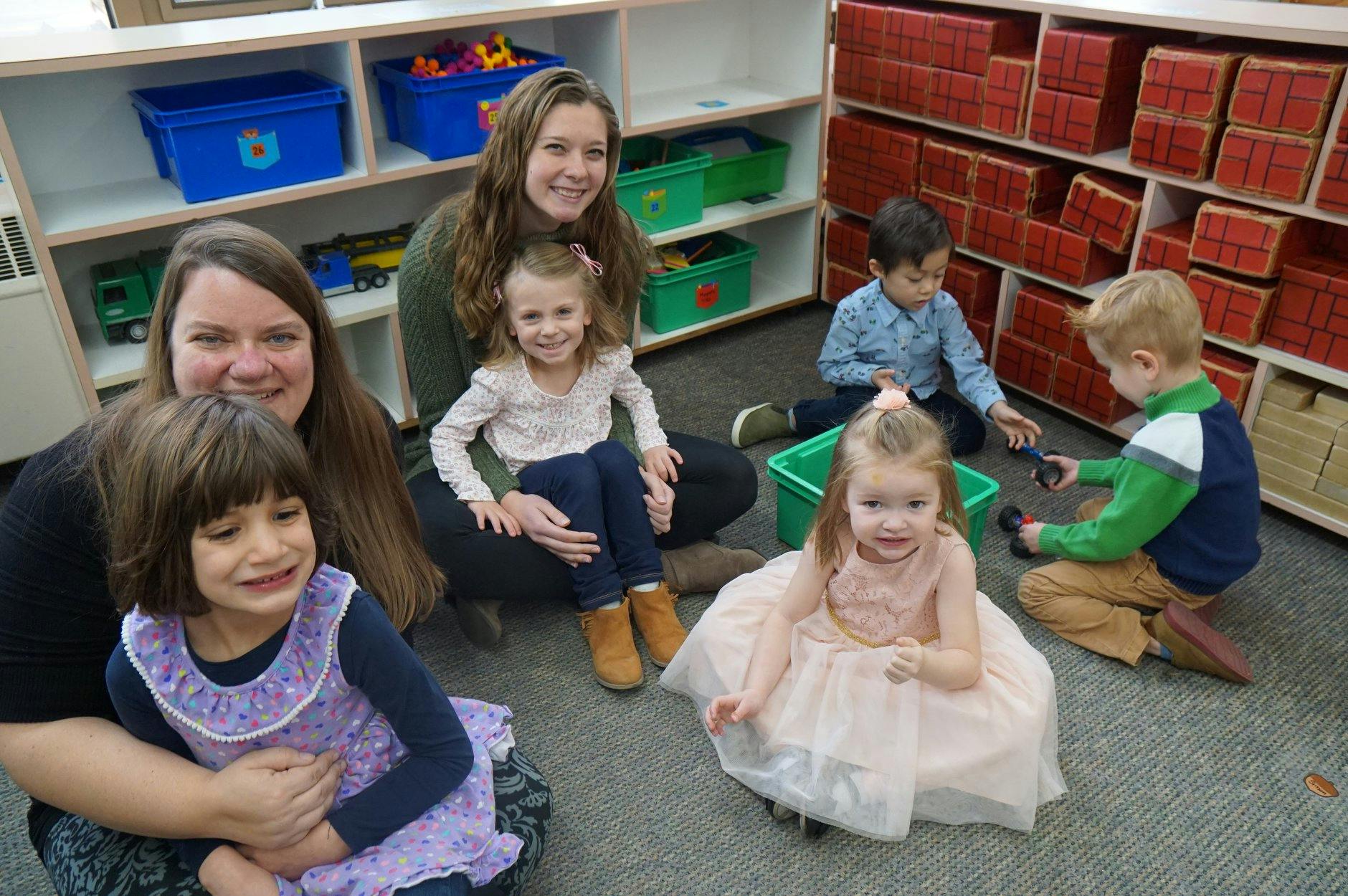 Two women and four children in a classroom