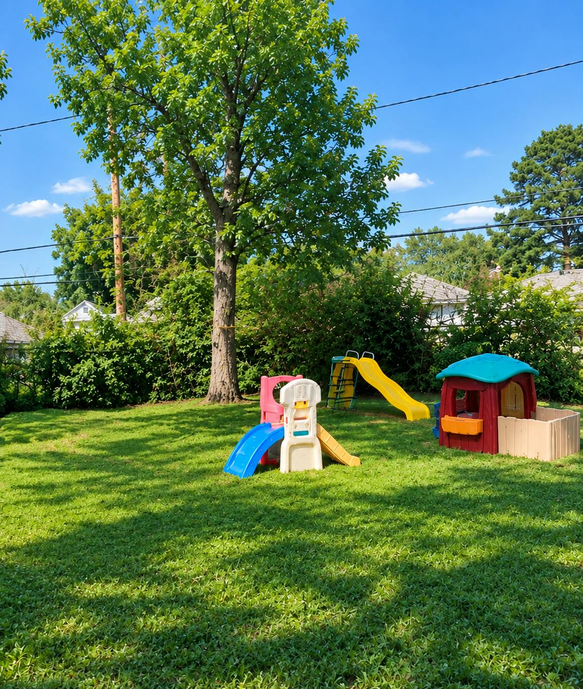 Plastic slides and playhouse in a backyard