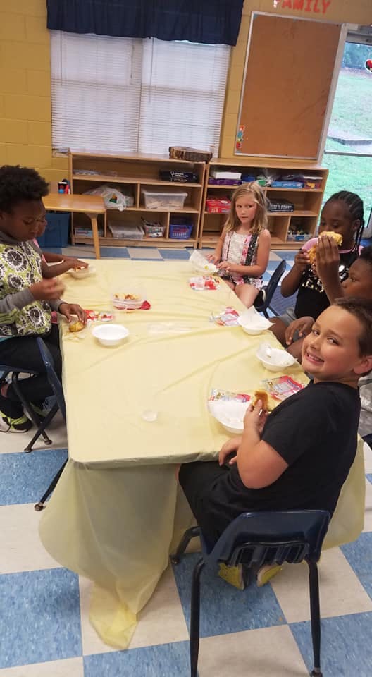Children sitting around a table with snacks