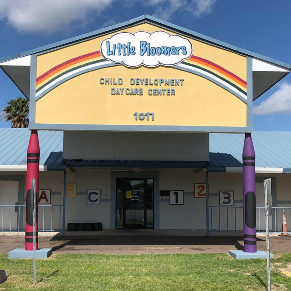 Little Bloomers Child Development Day Care Center sign with crayon pillars