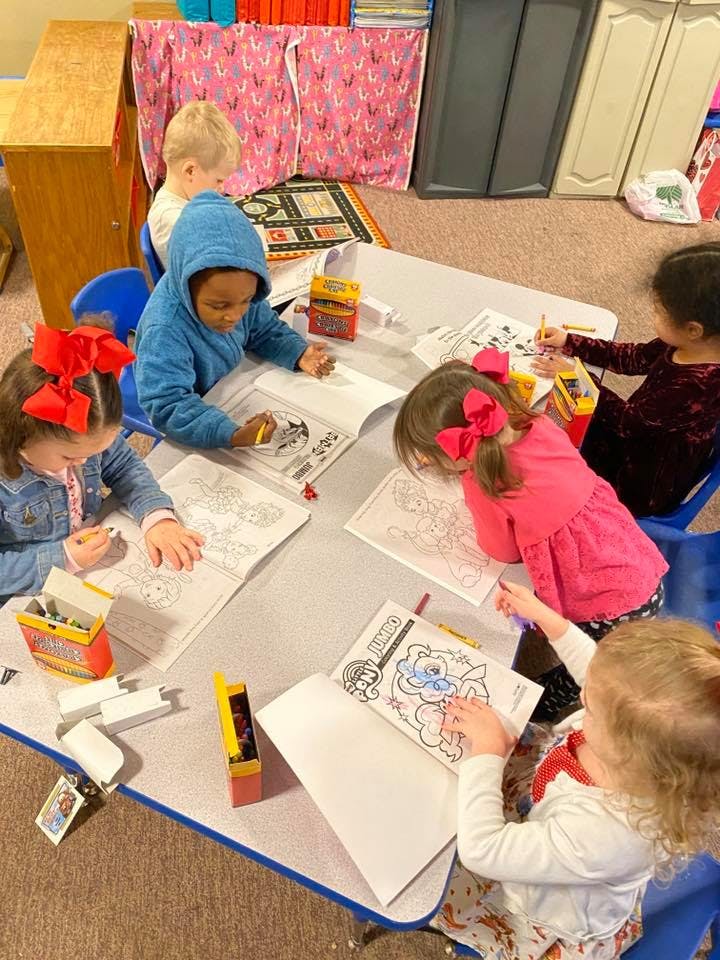 Children coloring at a table in a classroom