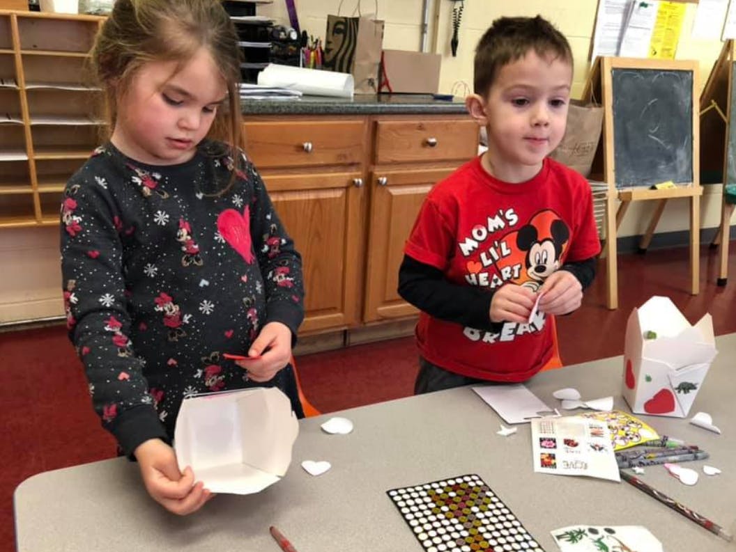 Two children at a table doing crafts