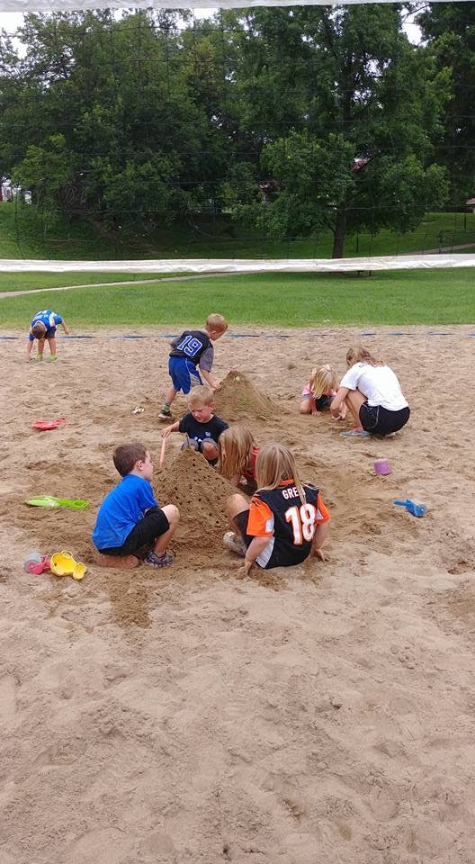 Children and adults playing in a sandbox
