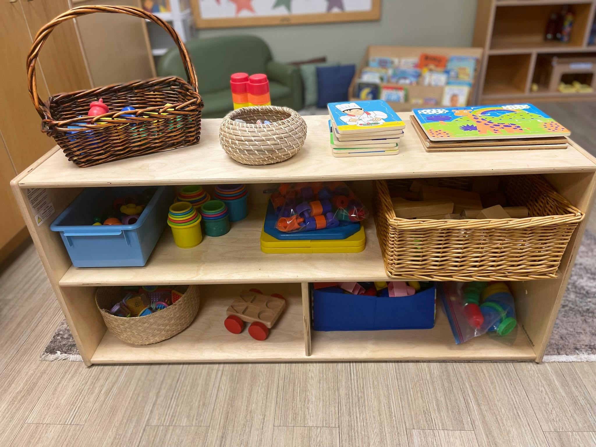 Wooden shelf with baskets, books, and toys in a classroom