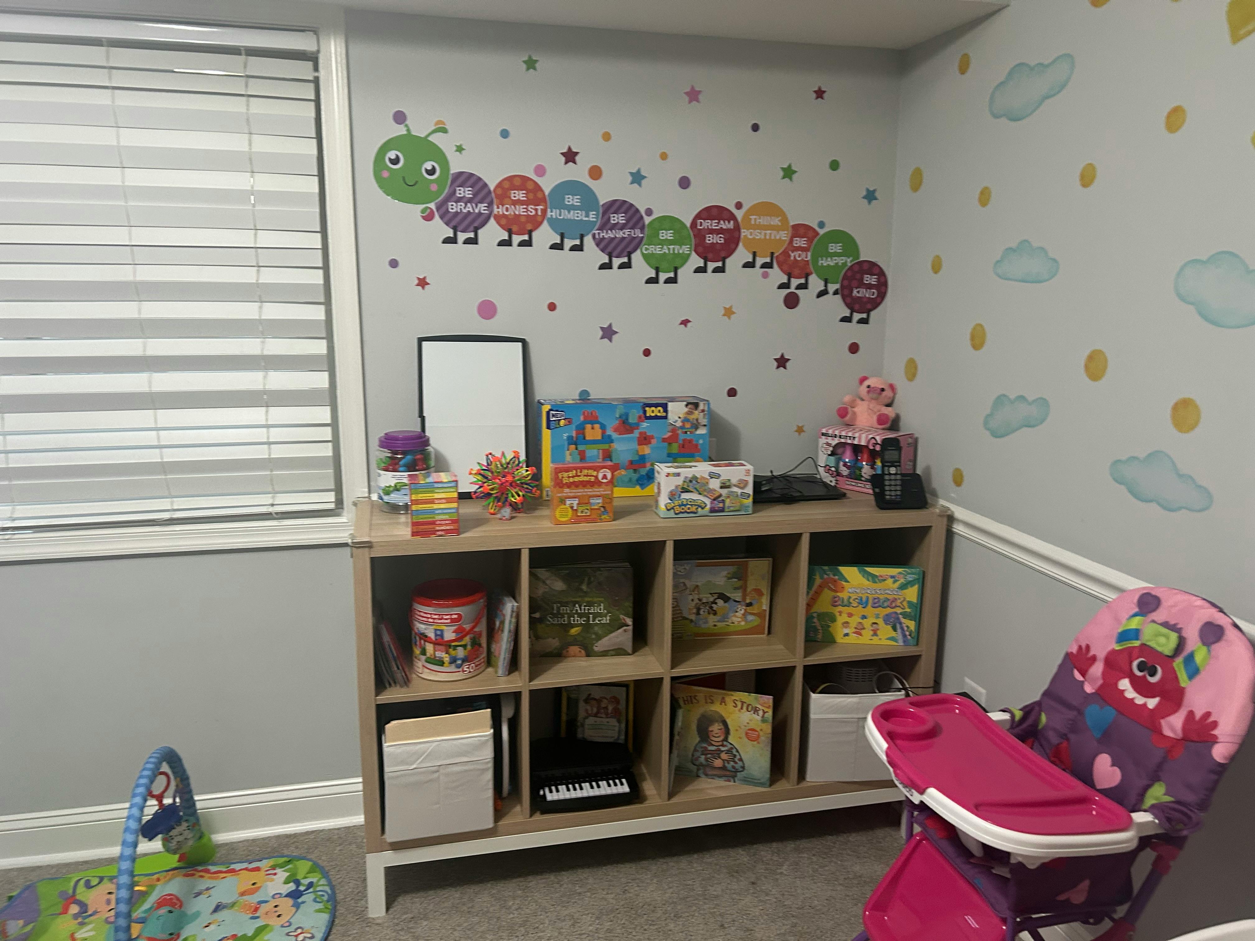 Playroom with a bookshelf, baby play mat, and high chair