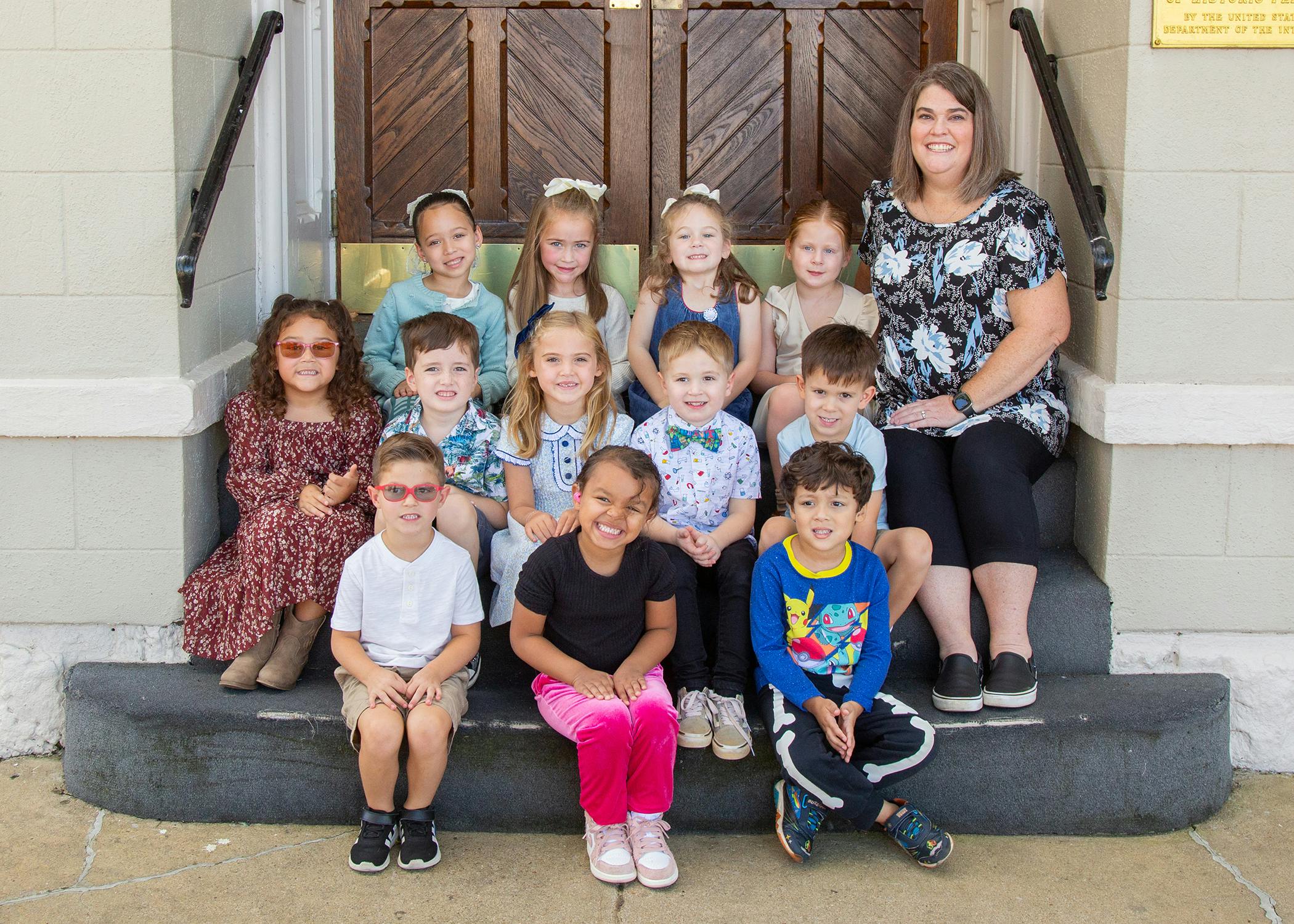 Adult and multiple children sitting on steps
