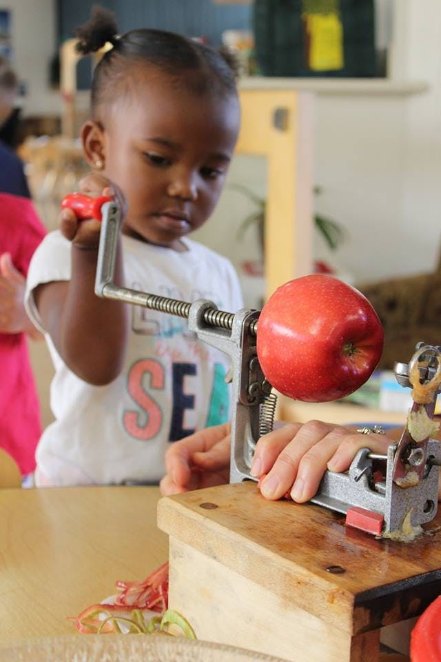 Child using an apple peeler