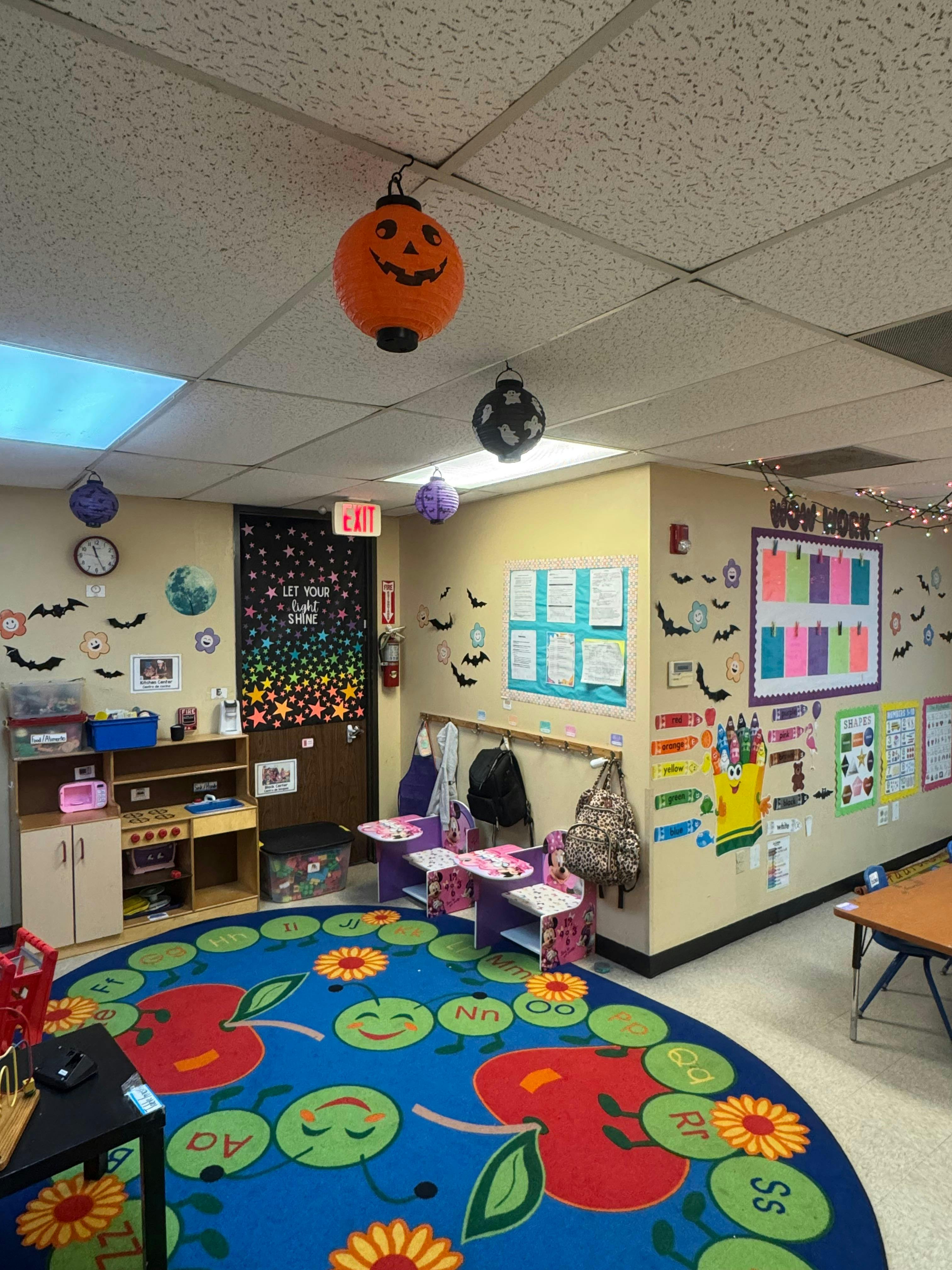 Classroom interior with Halloween decorations and a colorful alphabet rug