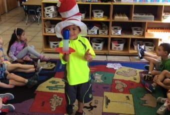 Child in Cat in the Hat costume holding a toy rocket