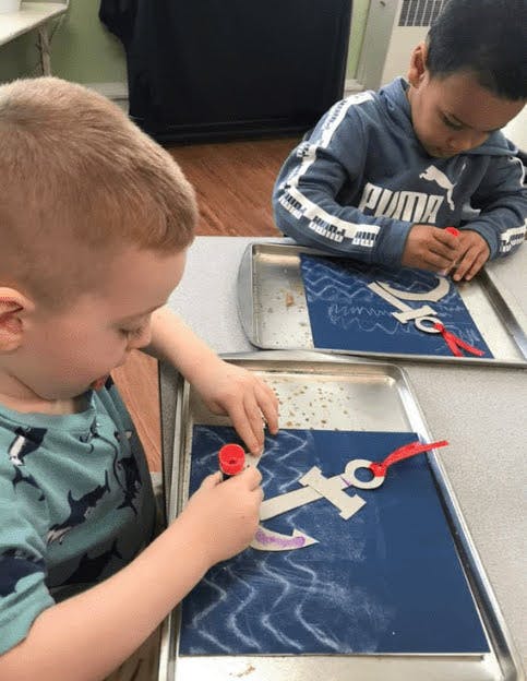 Two children doing crafts at a table