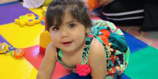 Child crawling on a colorful mat
