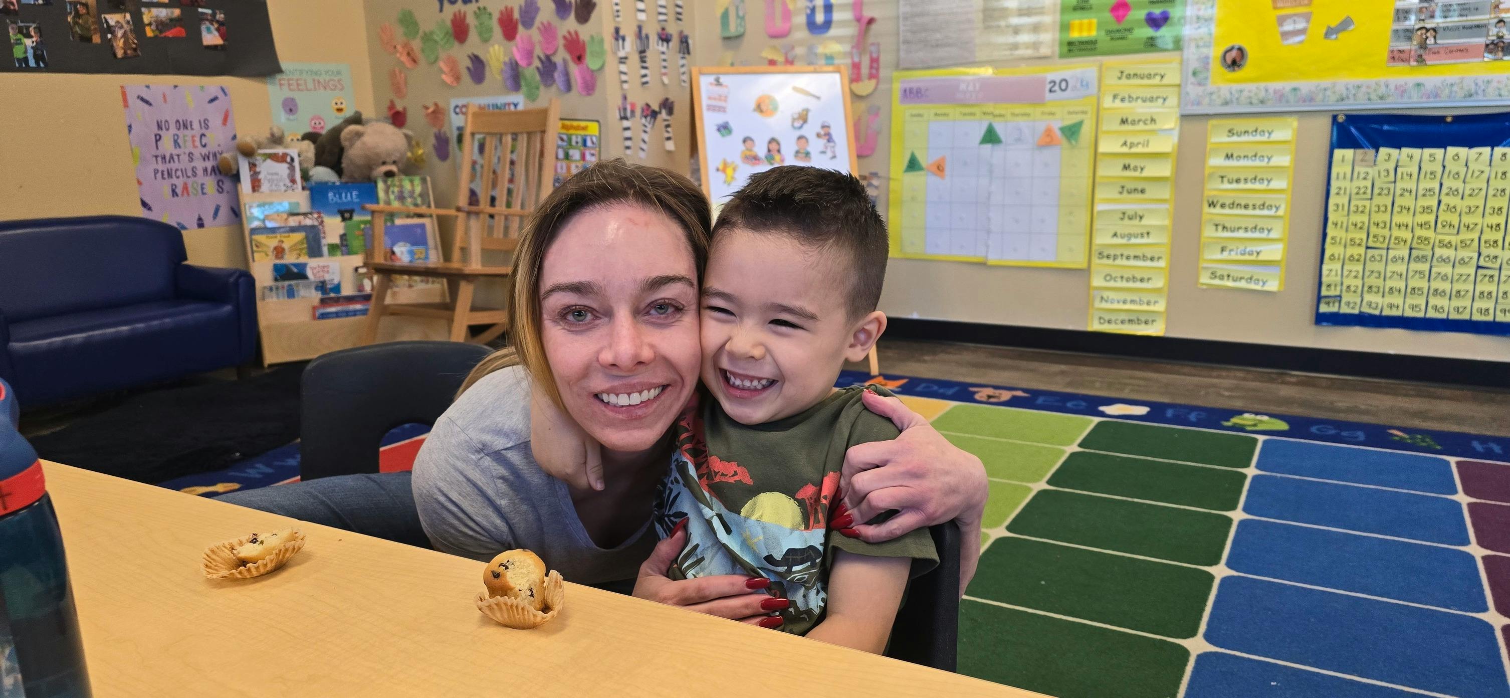 Adult and child smiling in a classroom