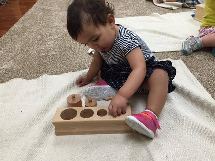 Child playing with a wooden shape sorter toy