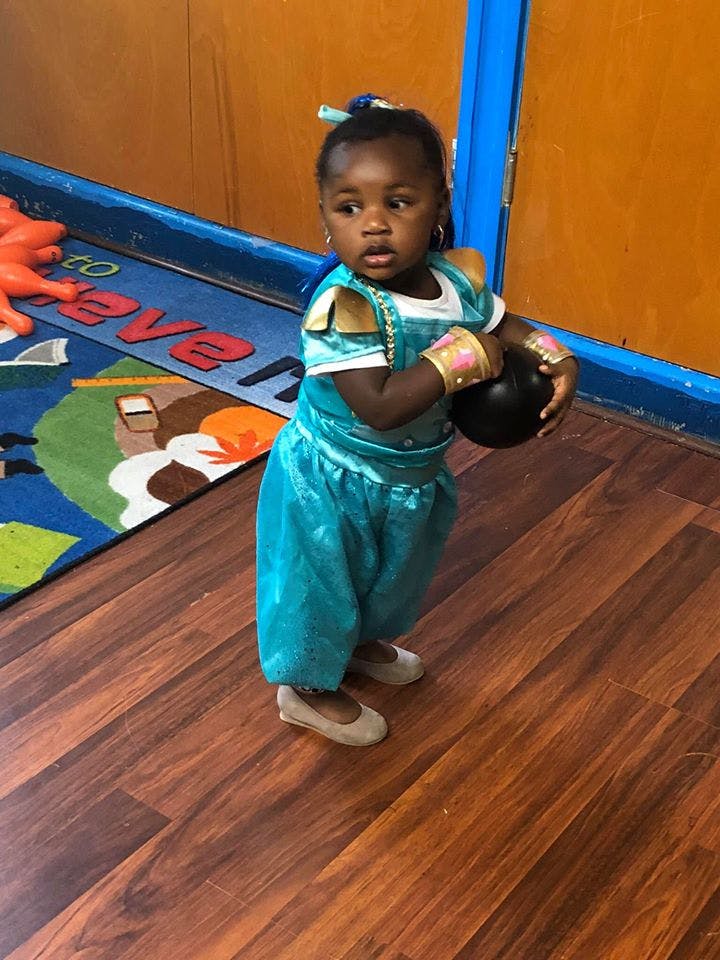 Child in costume holding a ball