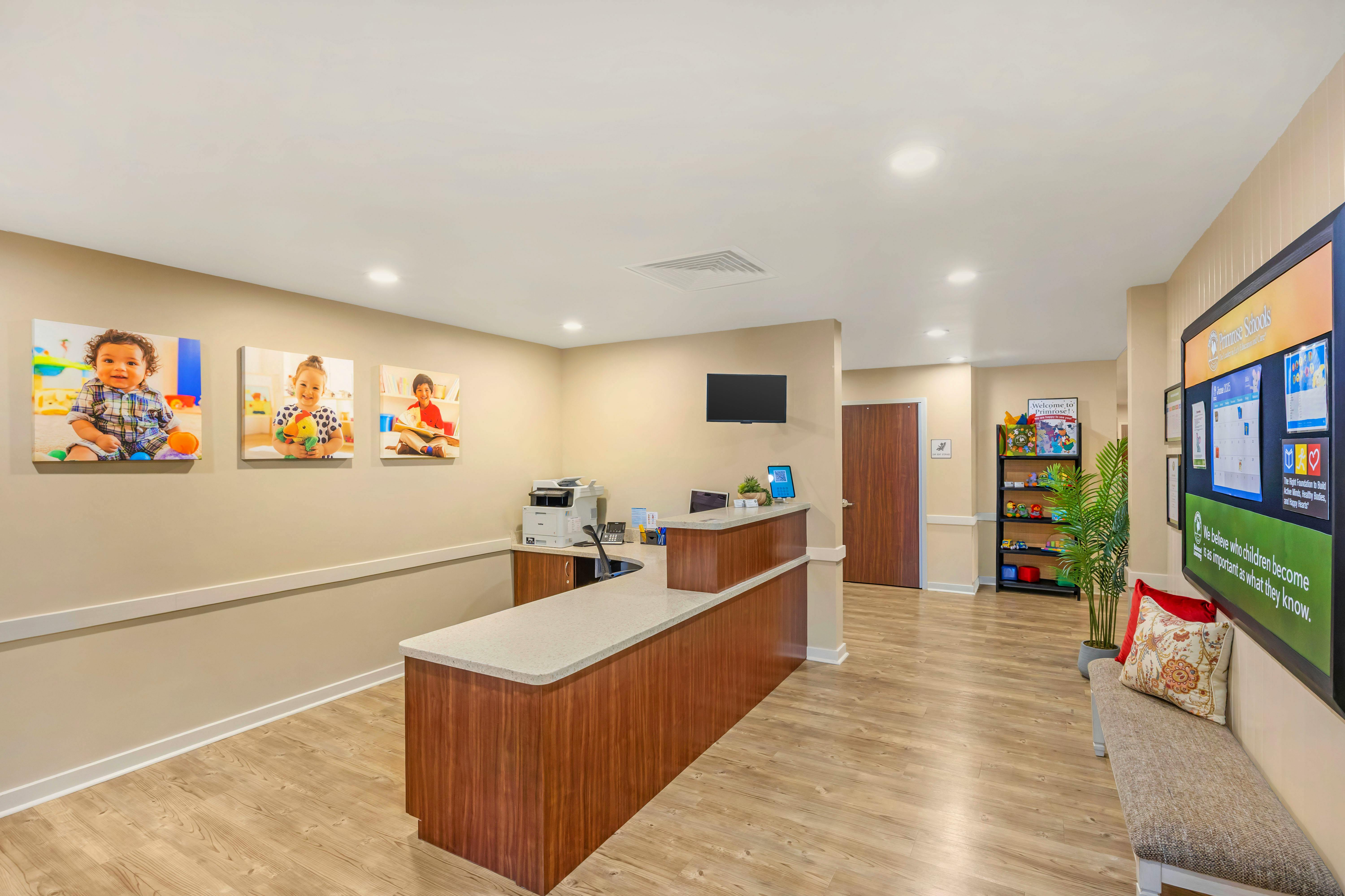 Reception desk in a childcare center with child portraits and an informational board