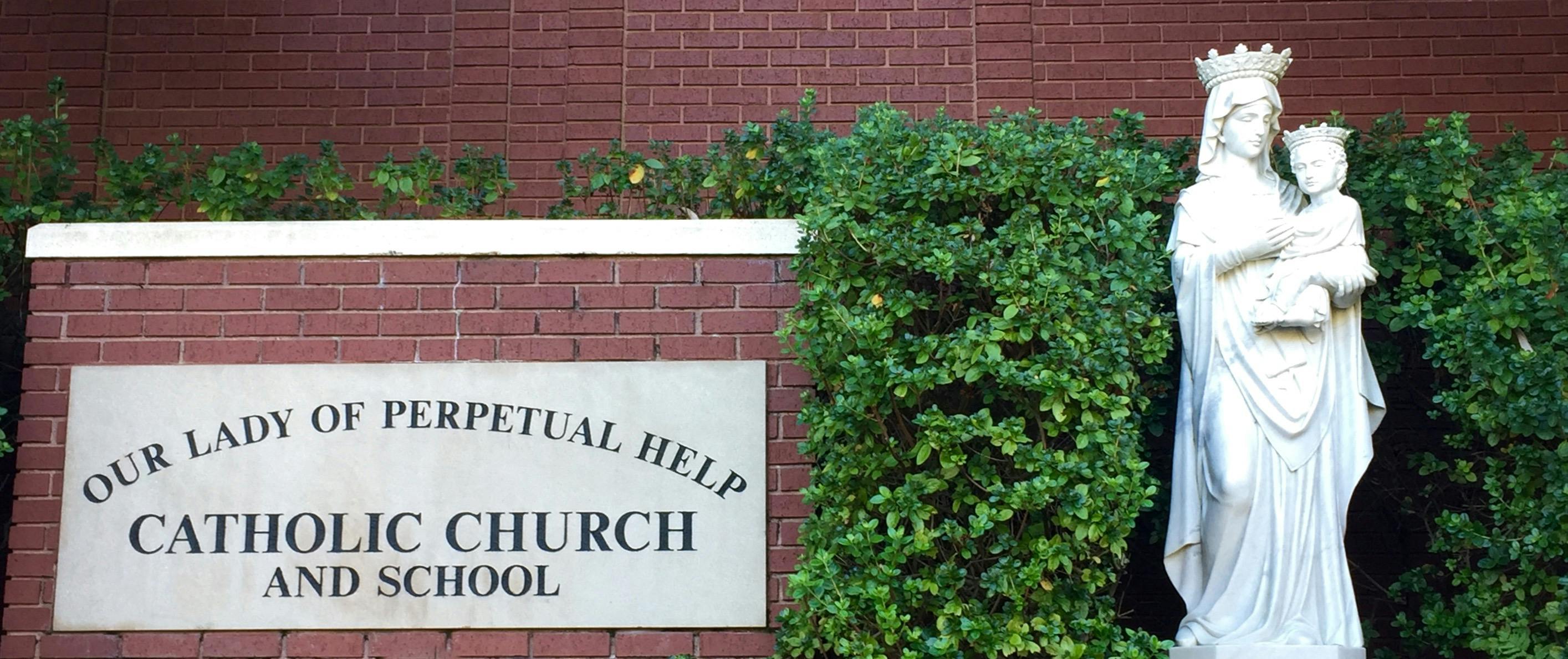 Sign for Our Lady of Perpetual Help Catholic Church and School with statue