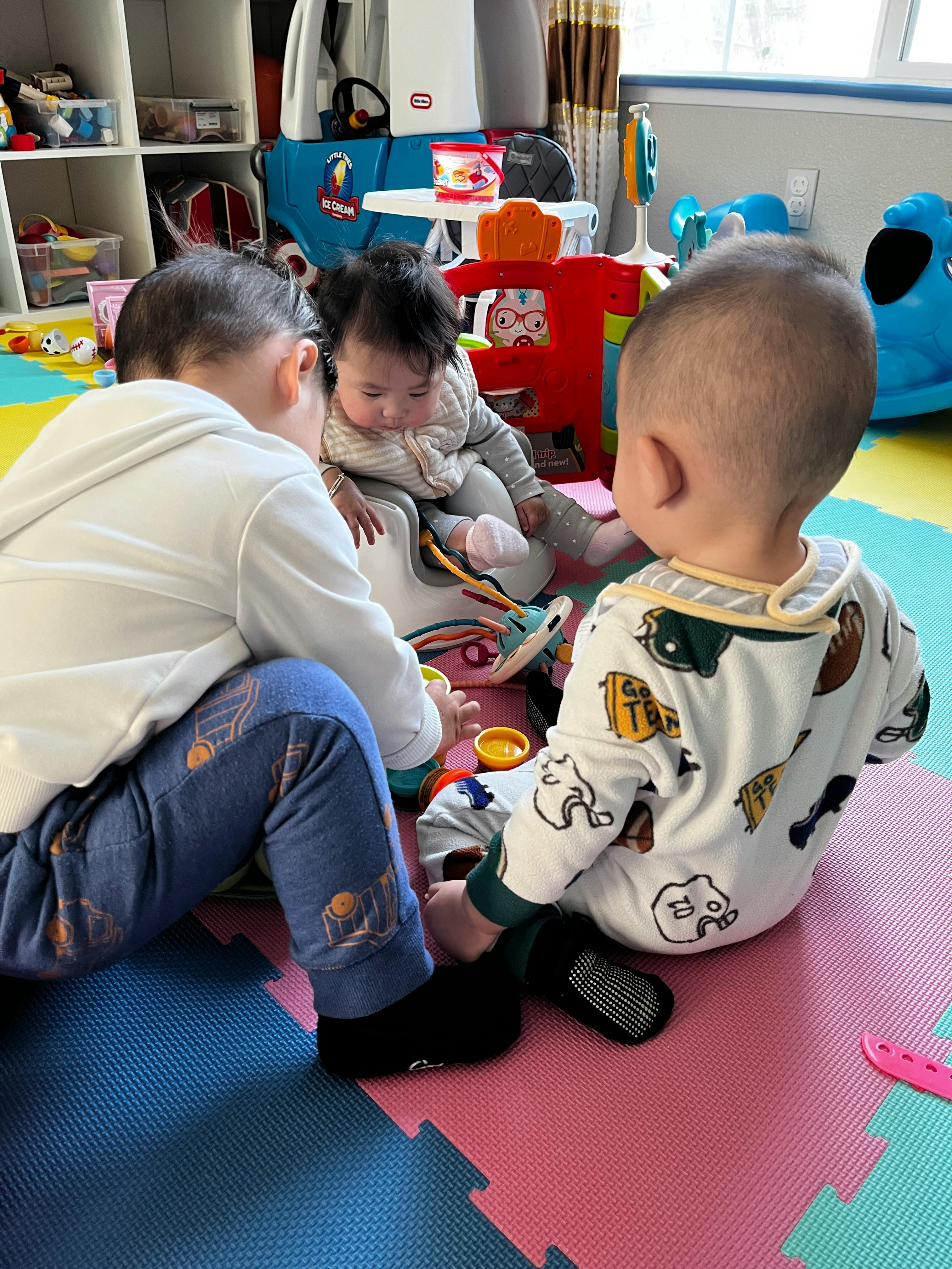 Three children playing on a colorful mat