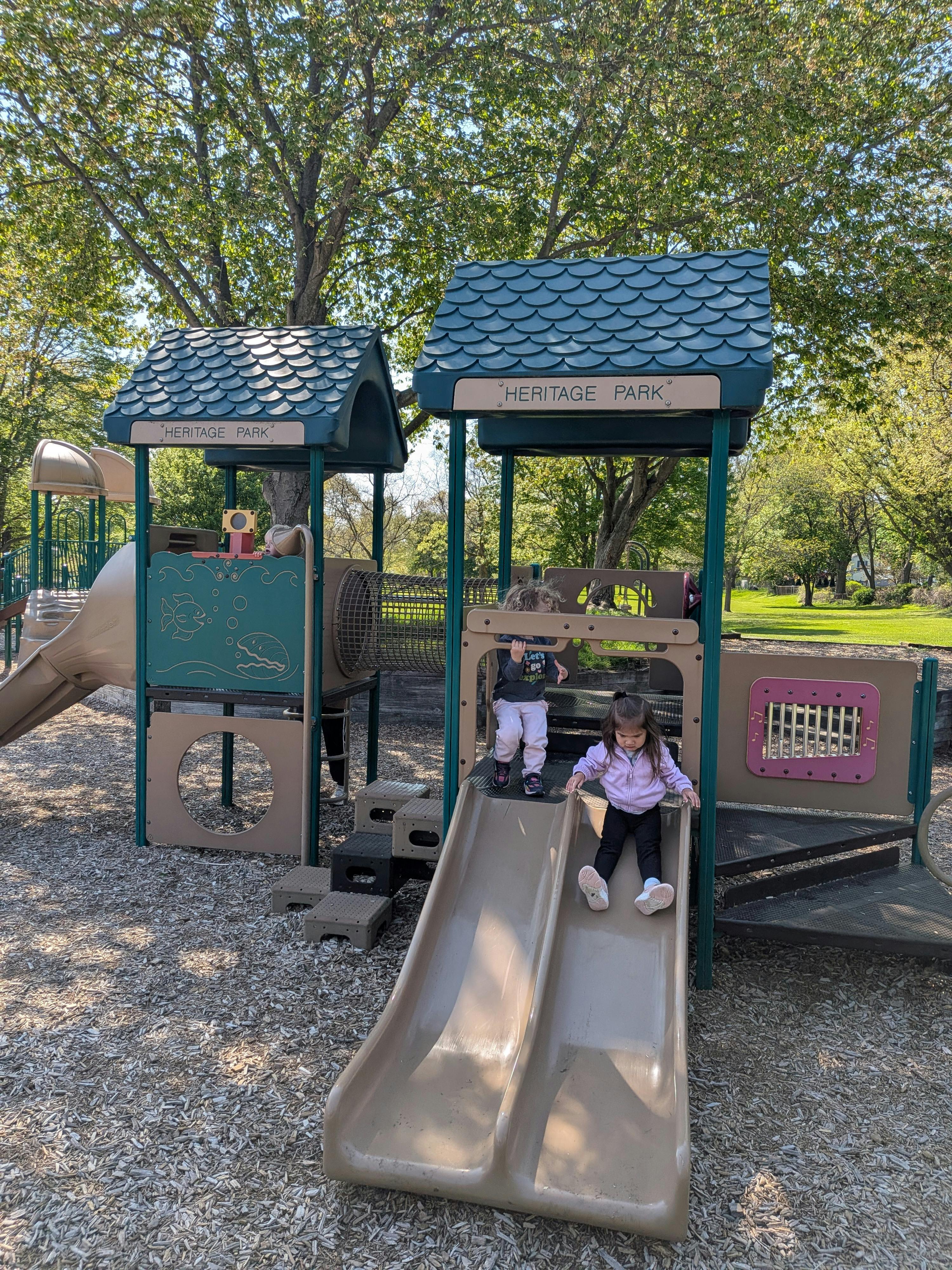 Children playing on a slide structure at Heritage Park