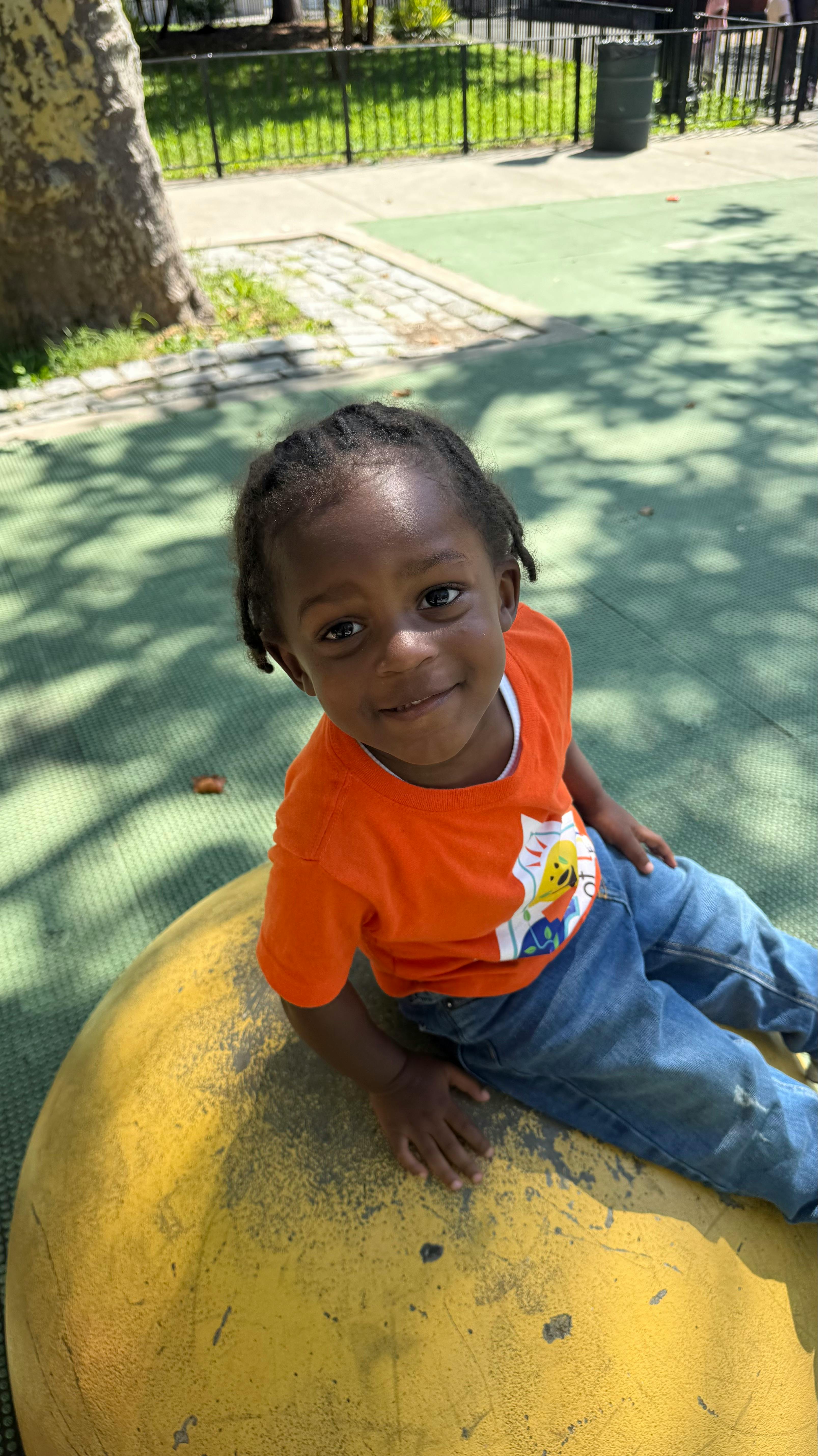Child sitting on a yellow playground structure