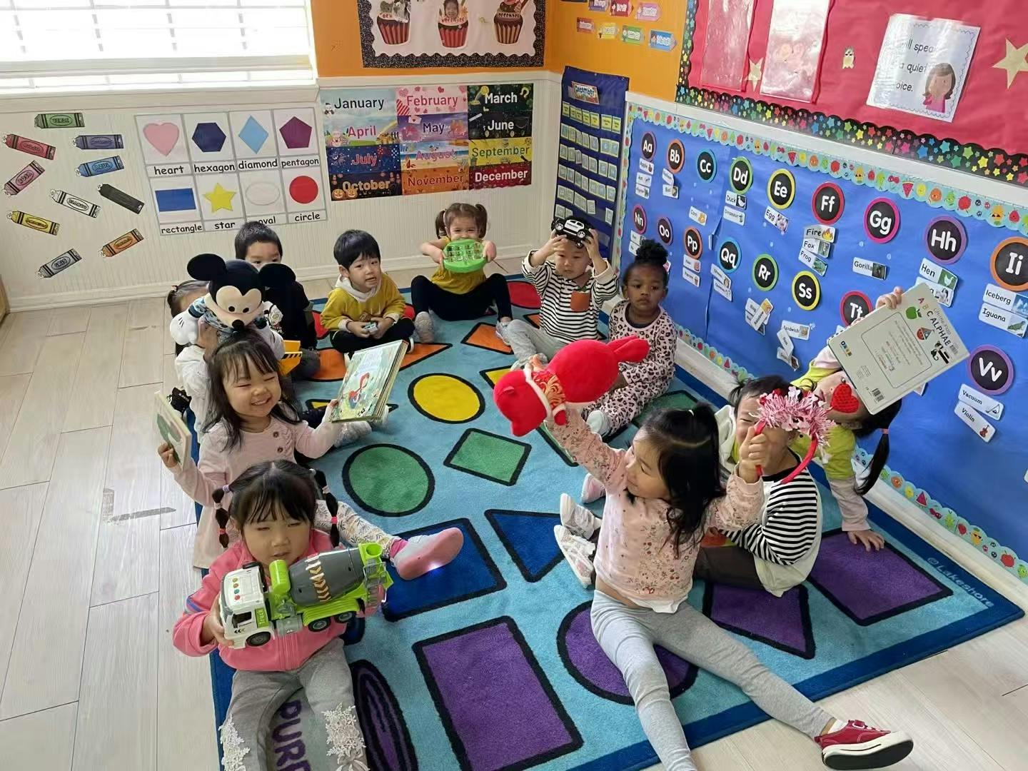 Children sitting on a rug with toys and books in a classroom