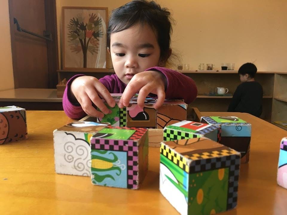 Child playing with colorful blocks on a table