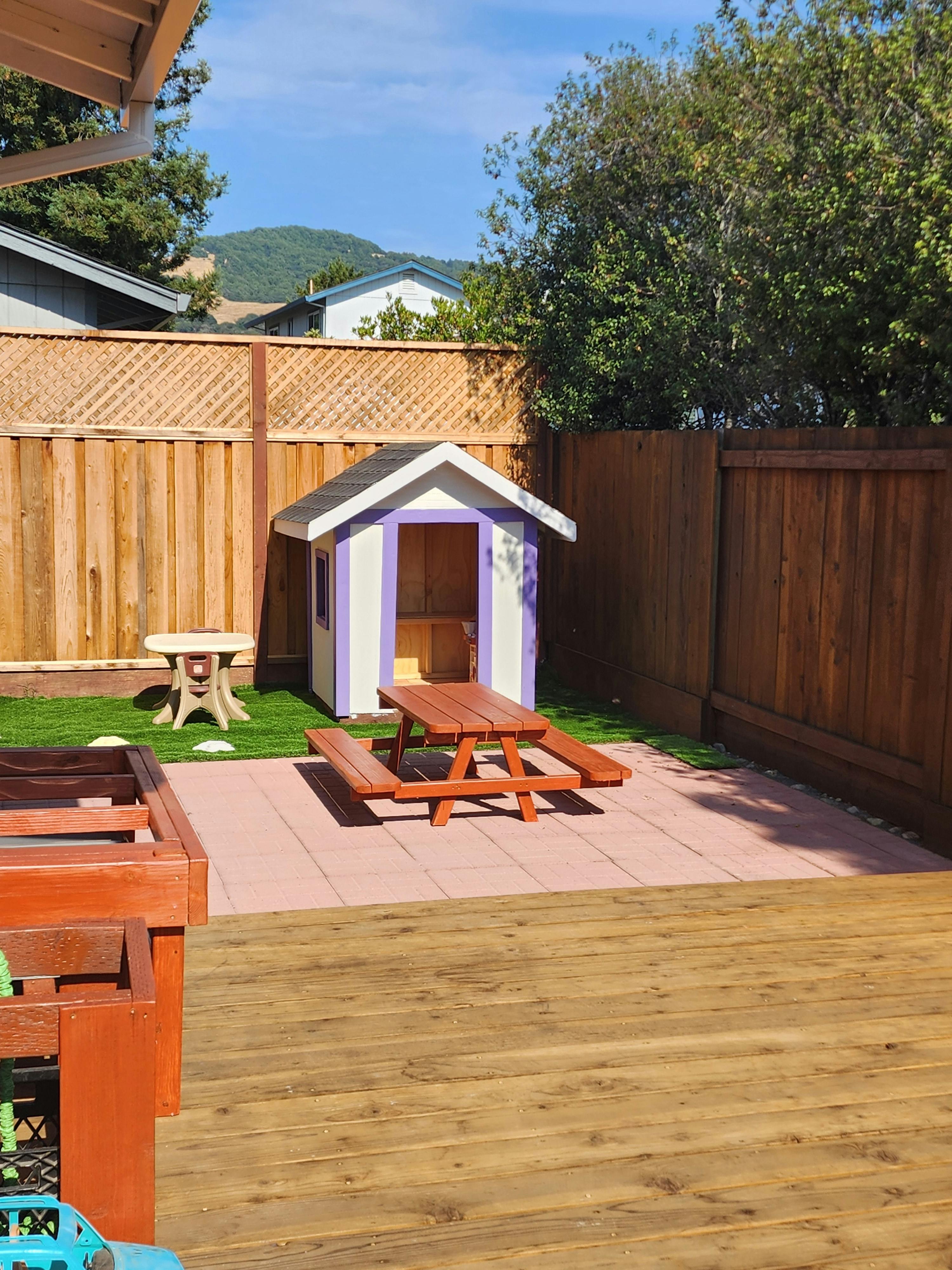 Playhouse and picnic table in a backyard