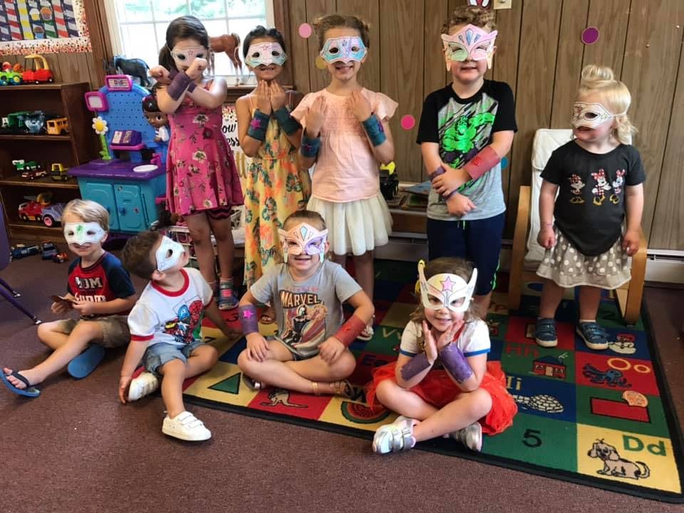 Group of children wearing superhero masks and costumes