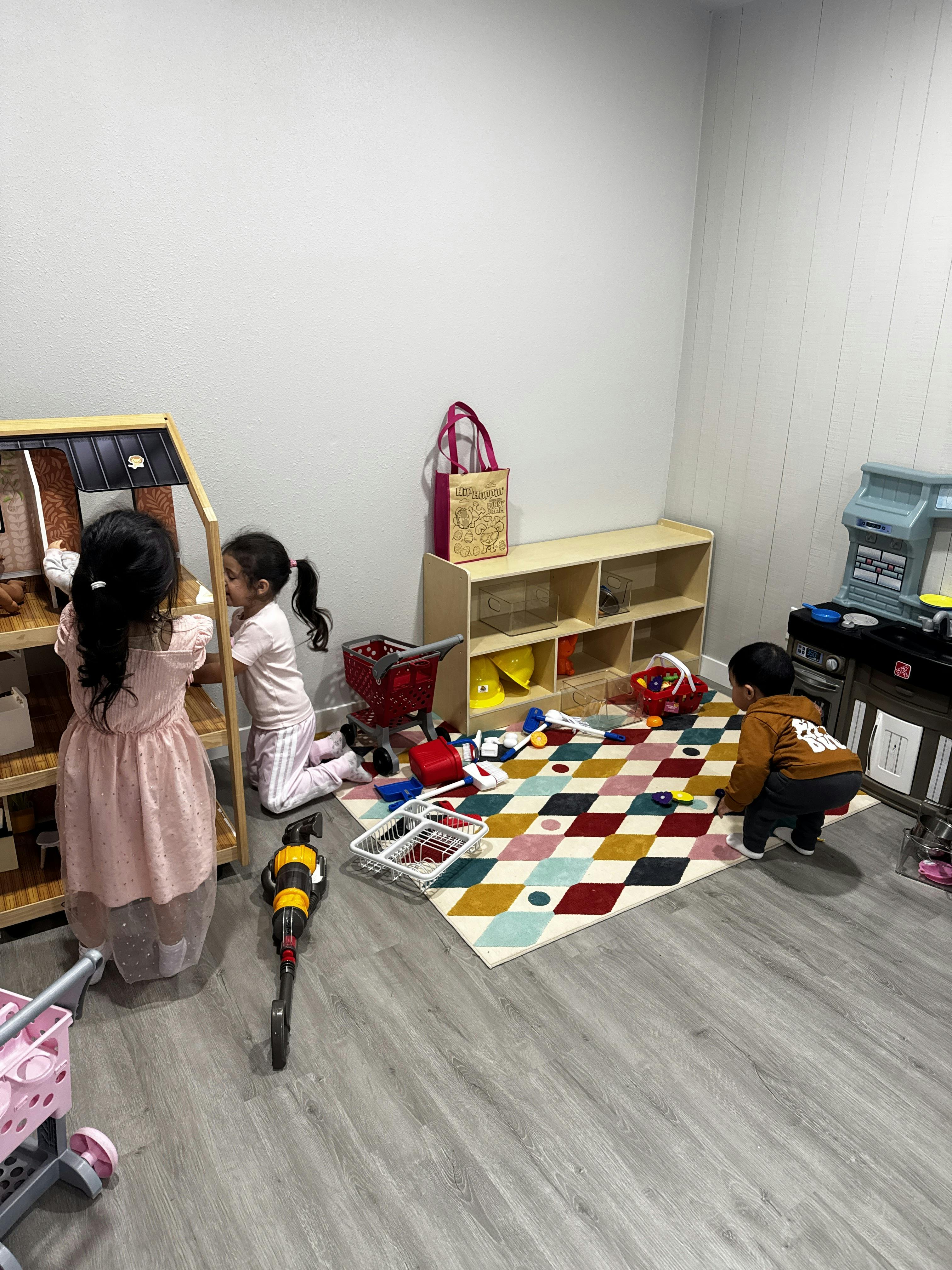 Three children playing with toys in a room