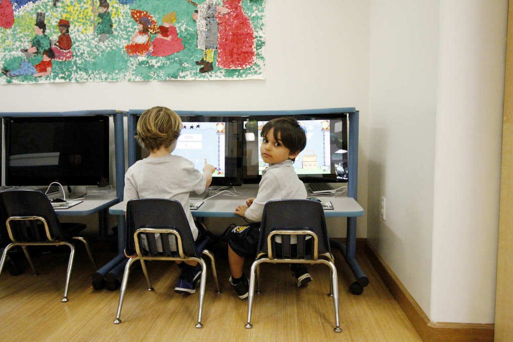 Two children sitting at computers in a classroom
