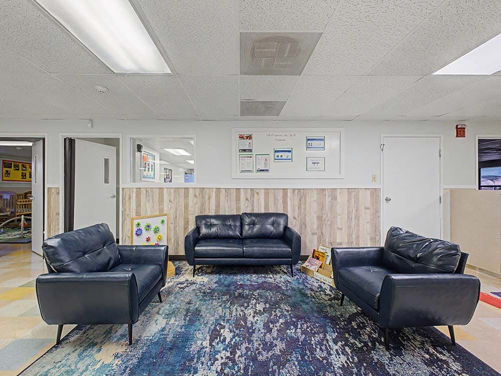Lounge area with black leather chairs and a sofa on a patterned rug
