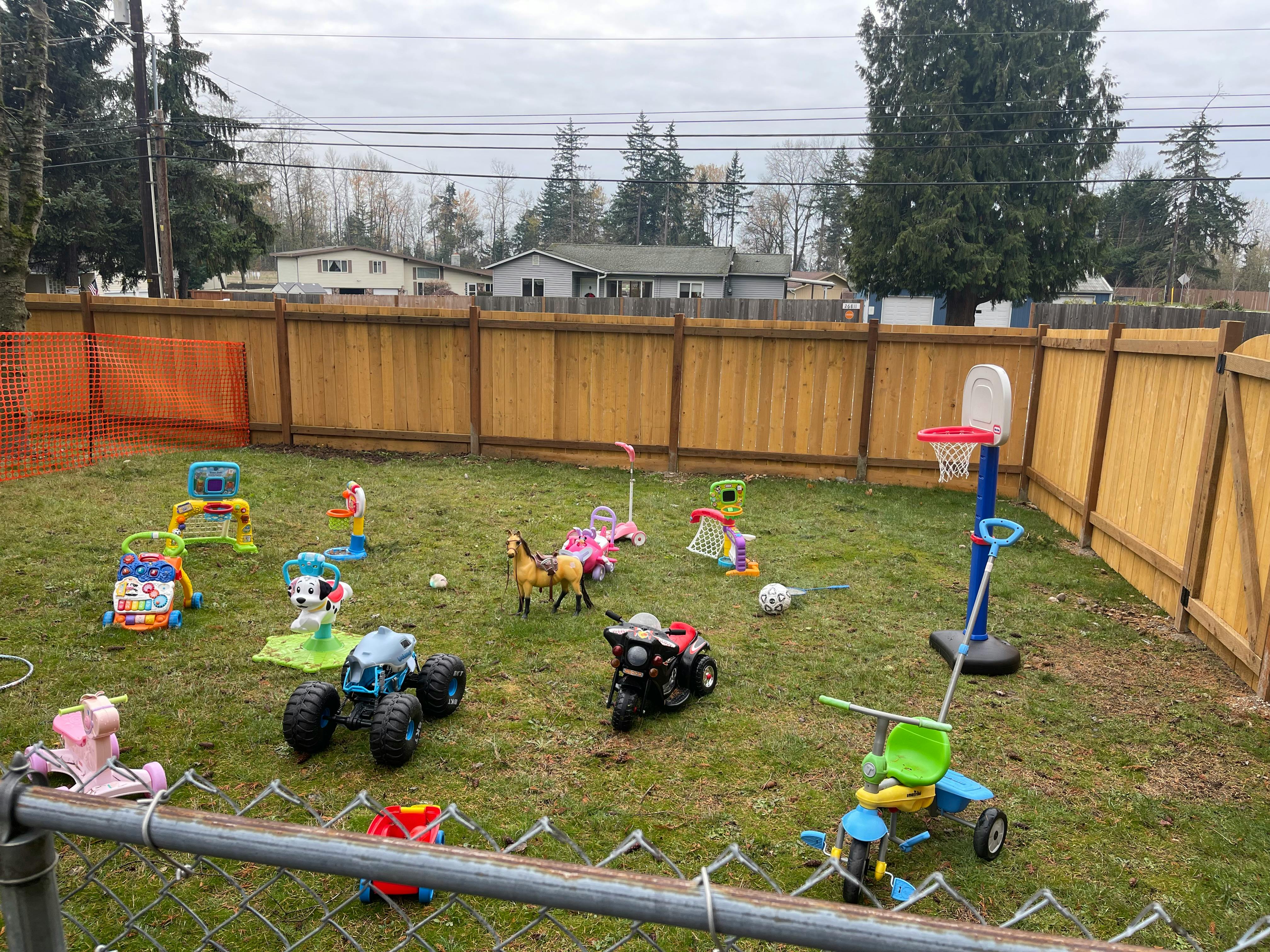 Outdoor play area with various toys on-ground toys and a small basketball hoop