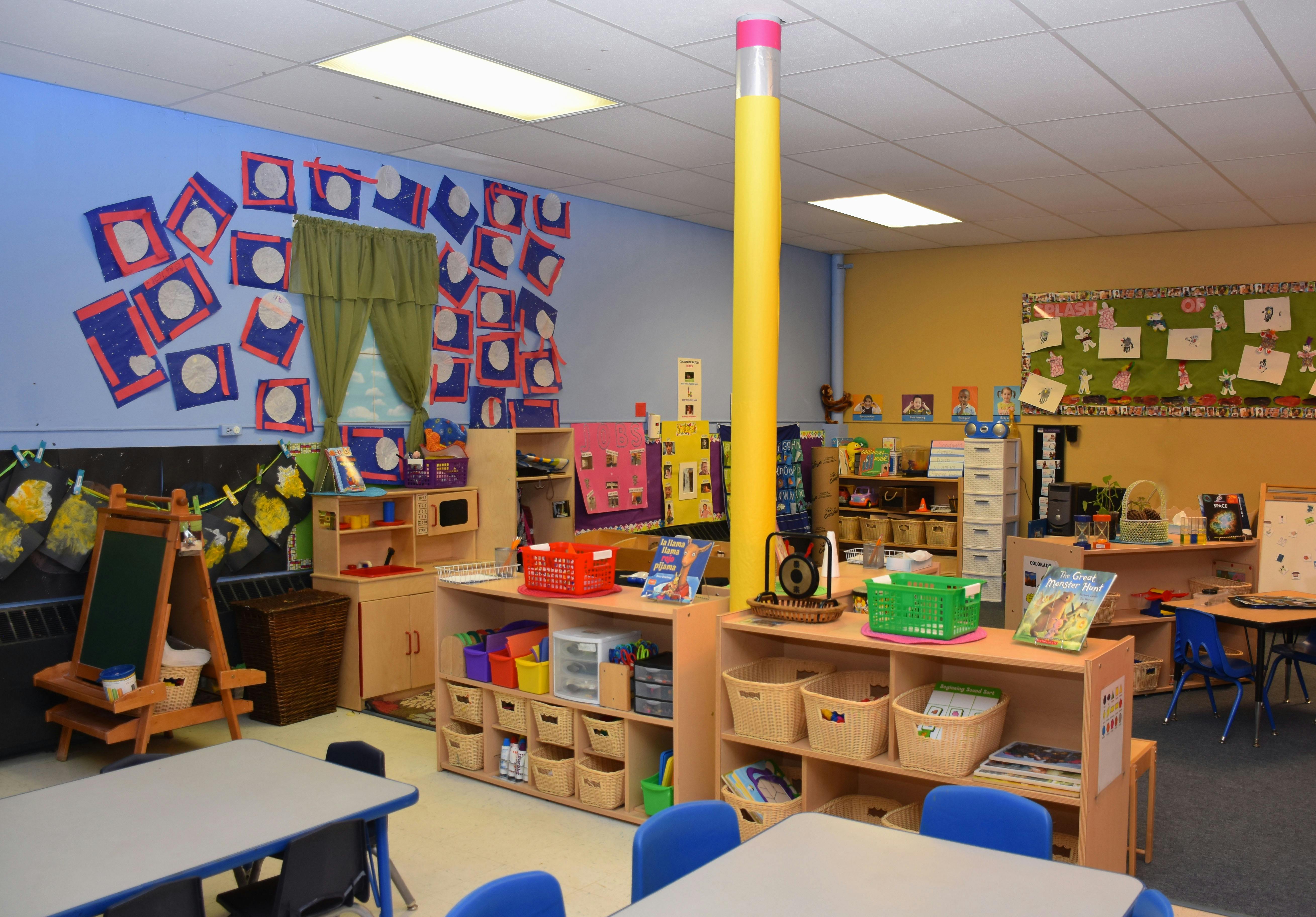 Colorful classroom with tables, chairs, shelves, and decorations