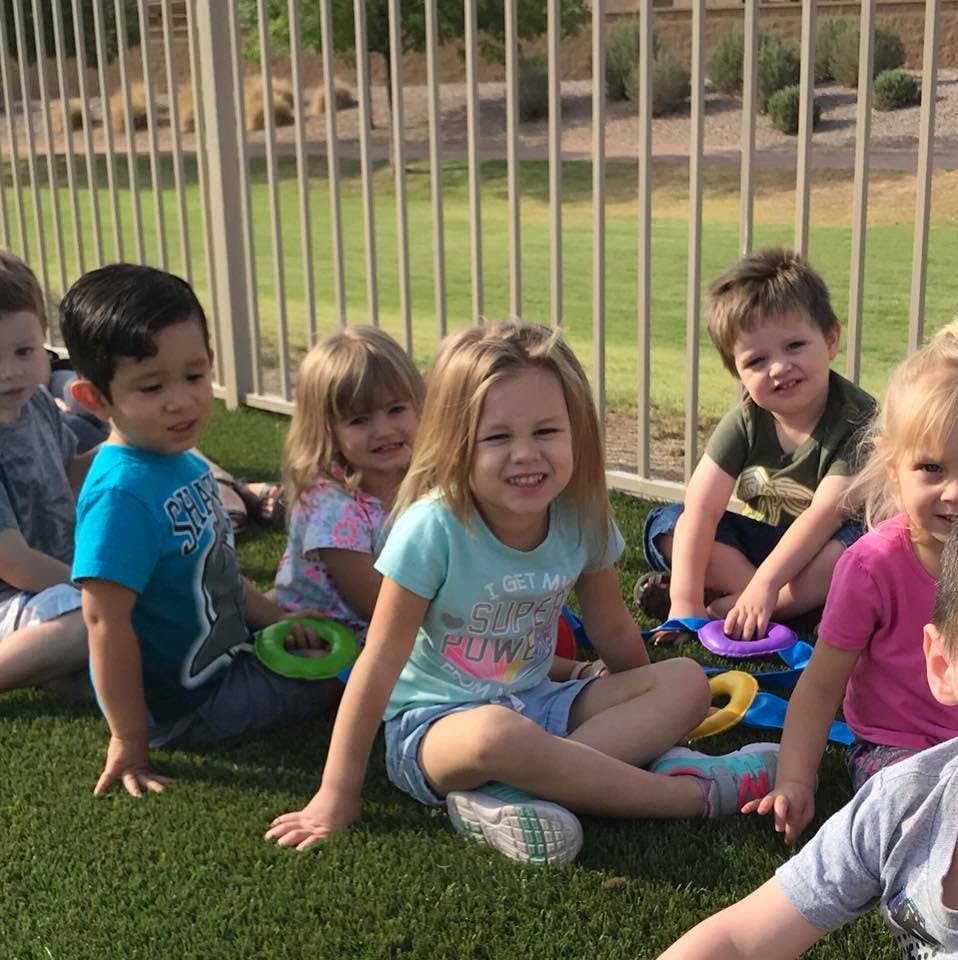 Group of children sitting on grass outdoors