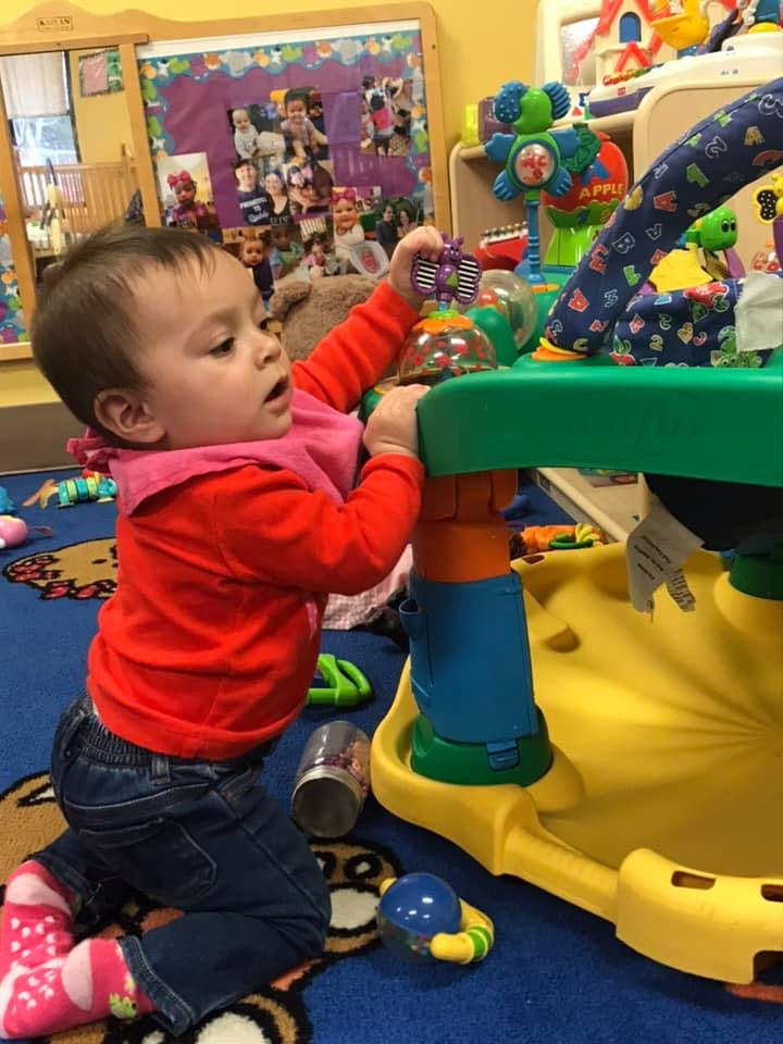 Child playing with a colorful activity table