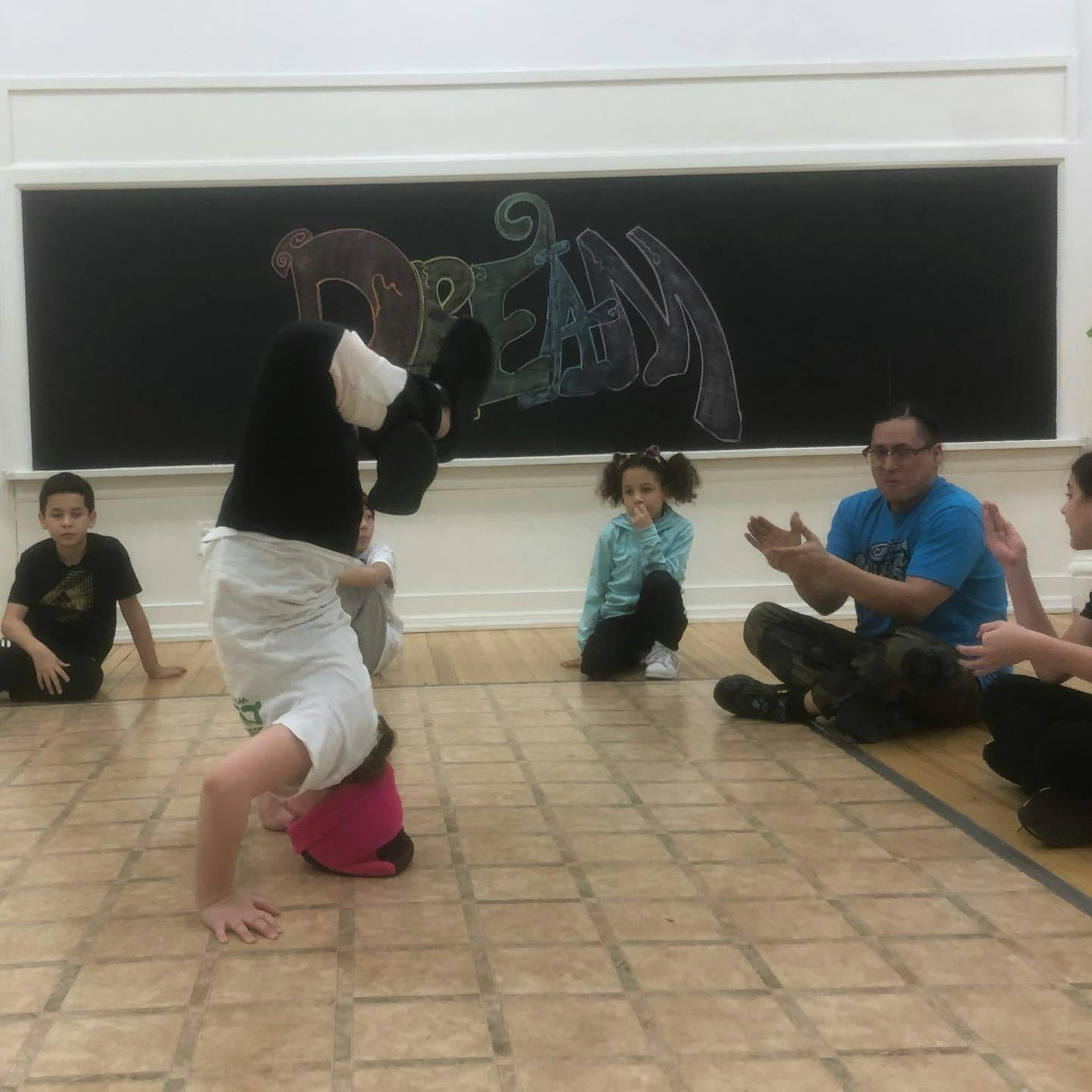 Child doing a headstand while people watch