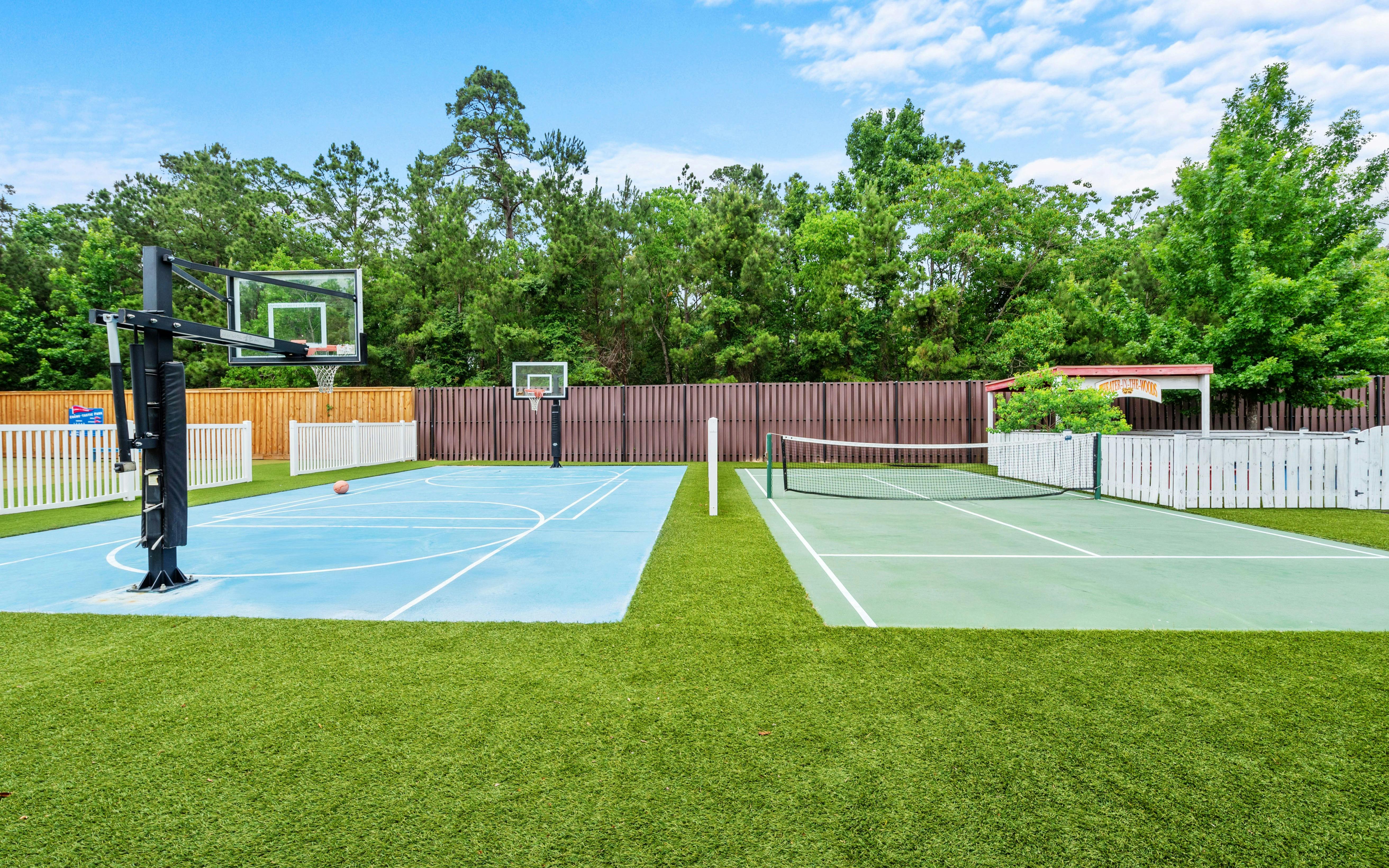 Basketball court and tennis court with fences and trees in the background